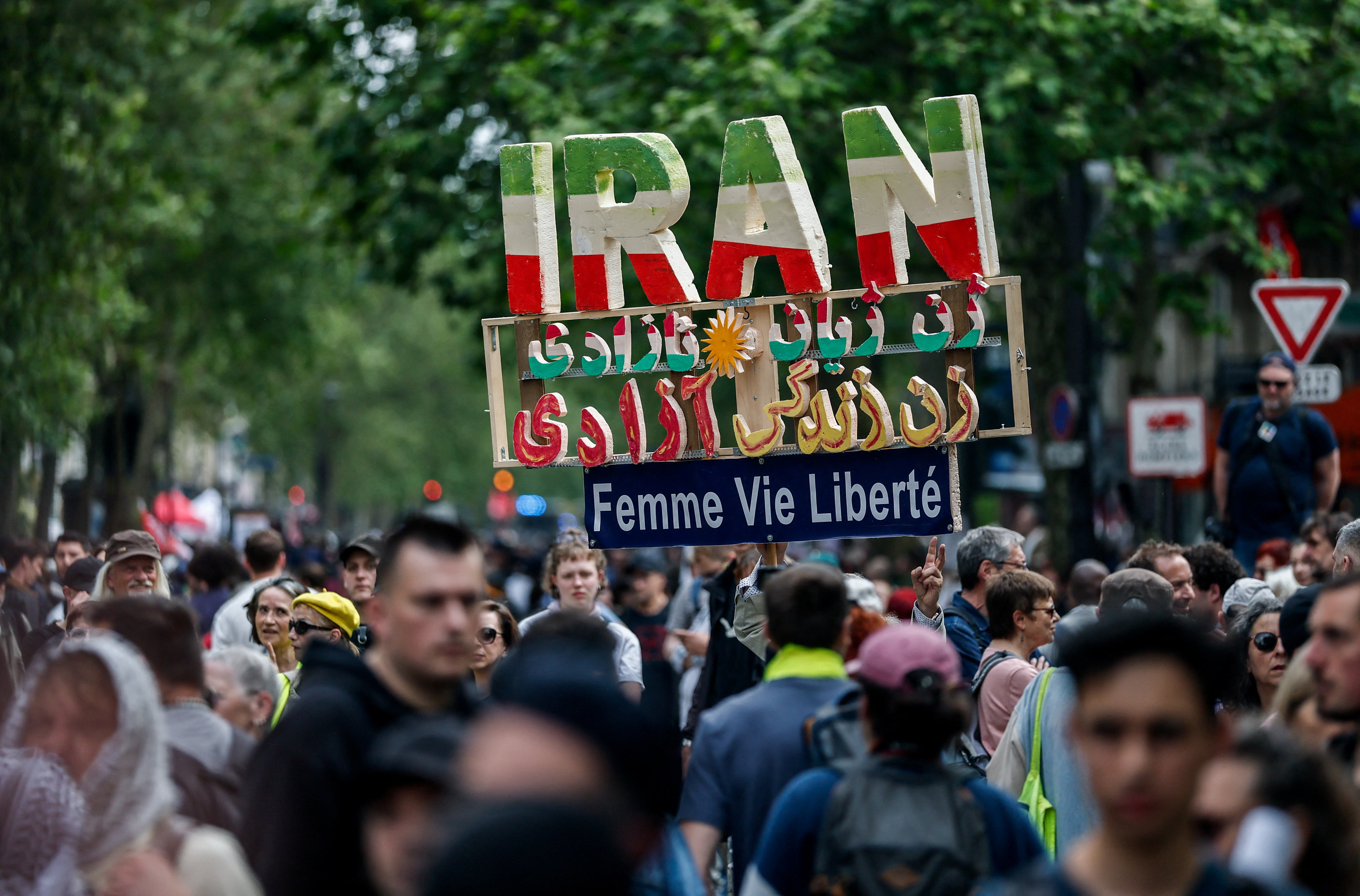 A protester holds a handmade sign with the letters forming the word Iran, during the traditional May Day labour union march in Paris, France, May 1, 2026. The slogan reads: "Woman, life, freedom". REUTERS/Benoit Tessier