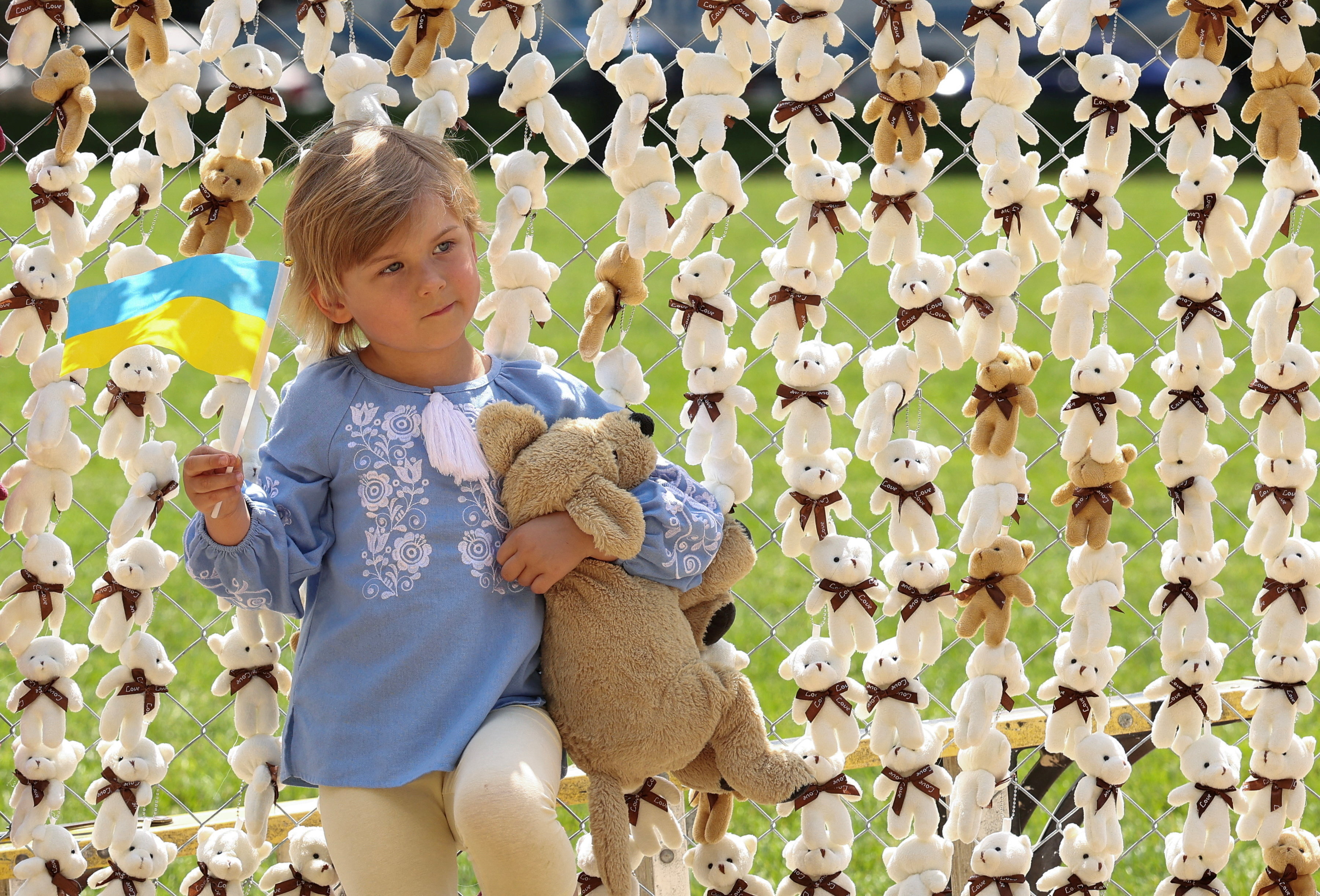 Ukraine-born Amieli Huzhevnikov, 4, holds a Ukraine flag while standing by some of the 20,000 teddy bears symbolizing Russian abductions of Ukraine children during a demonstration on the National Mall in Washington, D.C., U.S., April 23, 2026. REUTERS/Kevin Lamarque TPX IMAGES OF THE DAY