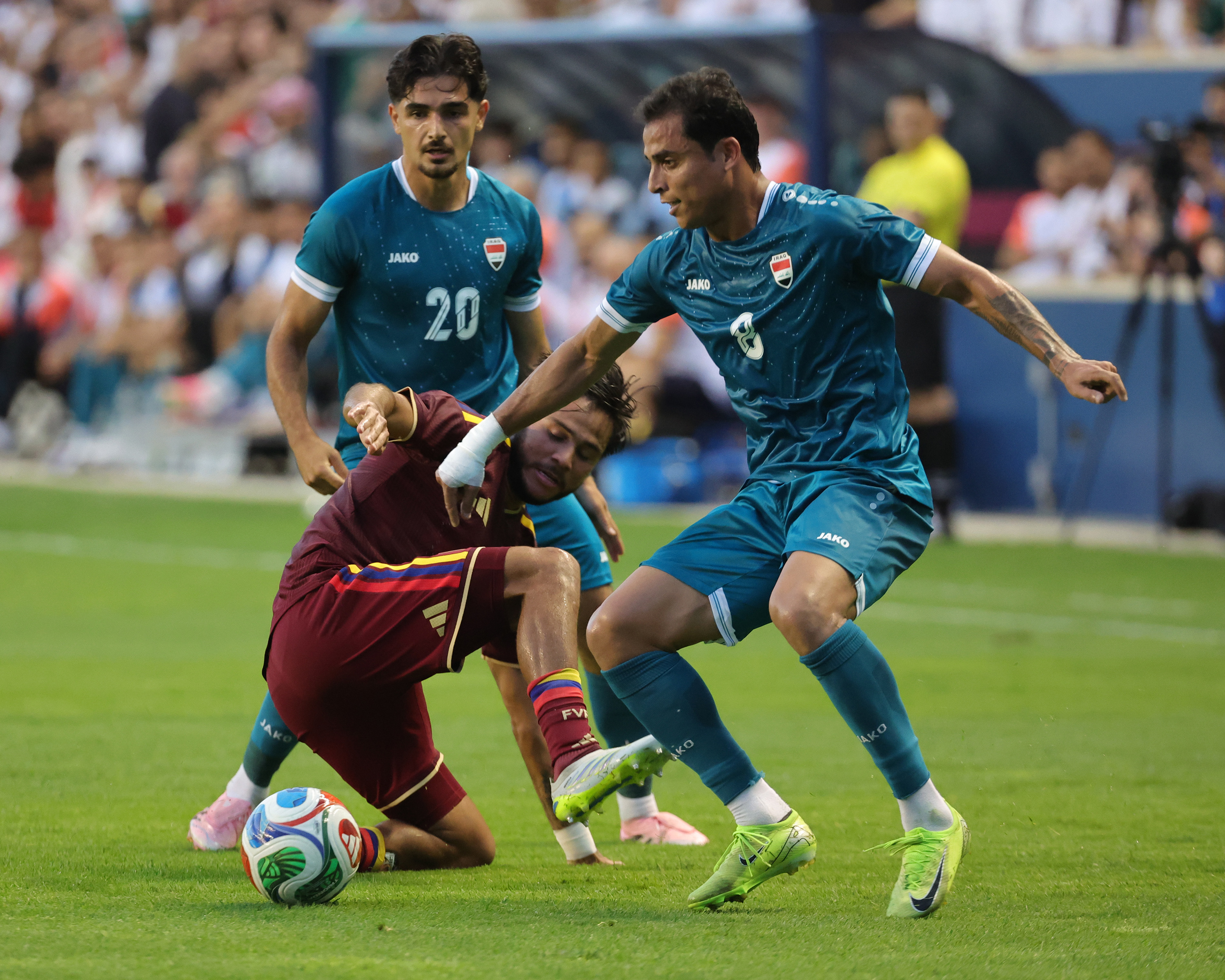 Iraq midfielder Aimar Sher (#20) attempts to steal the ball from Venezuela midfielder Yeferson Soteldo