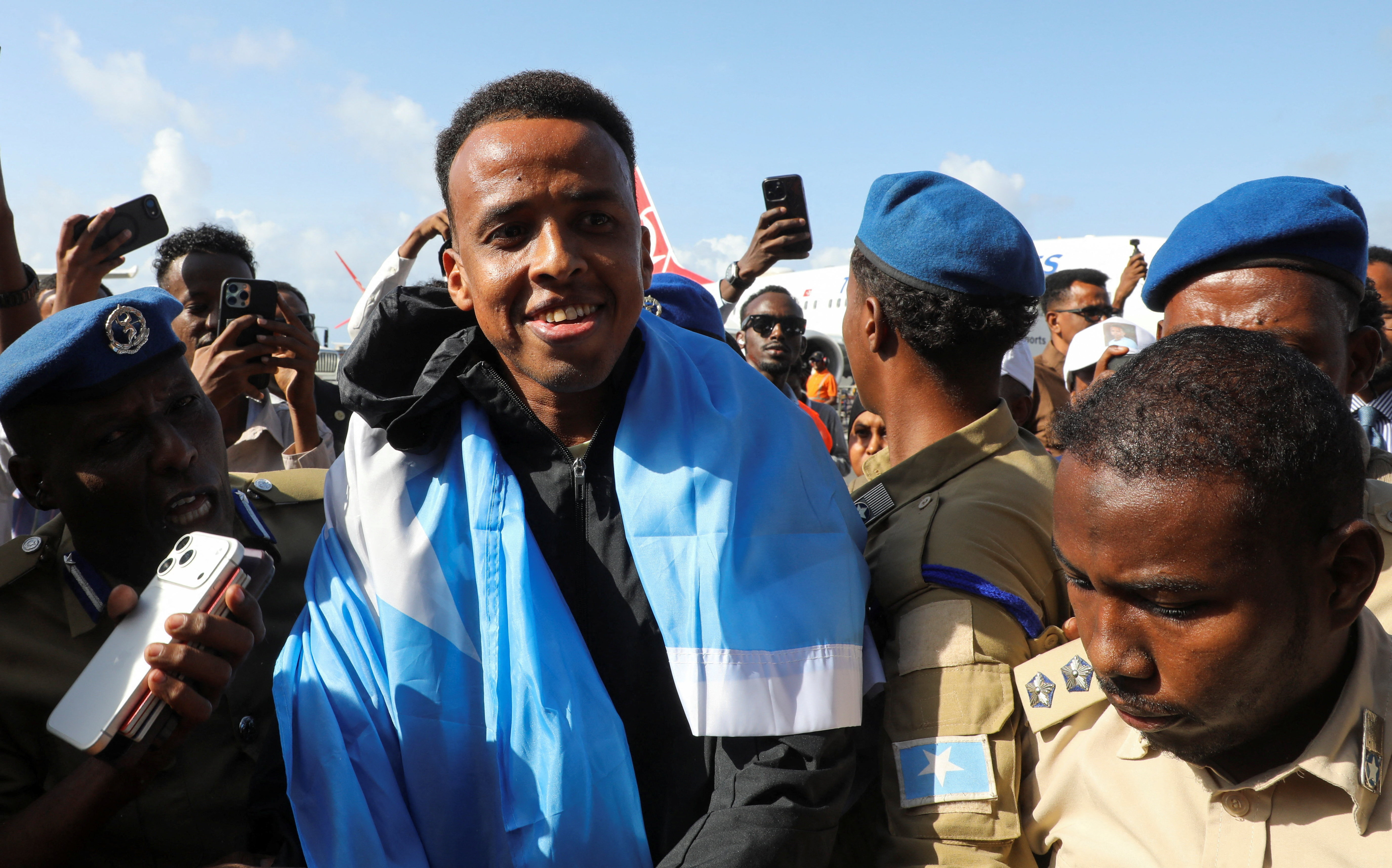 Omar Artan draped in a Somalian flag and surrounded by supporters