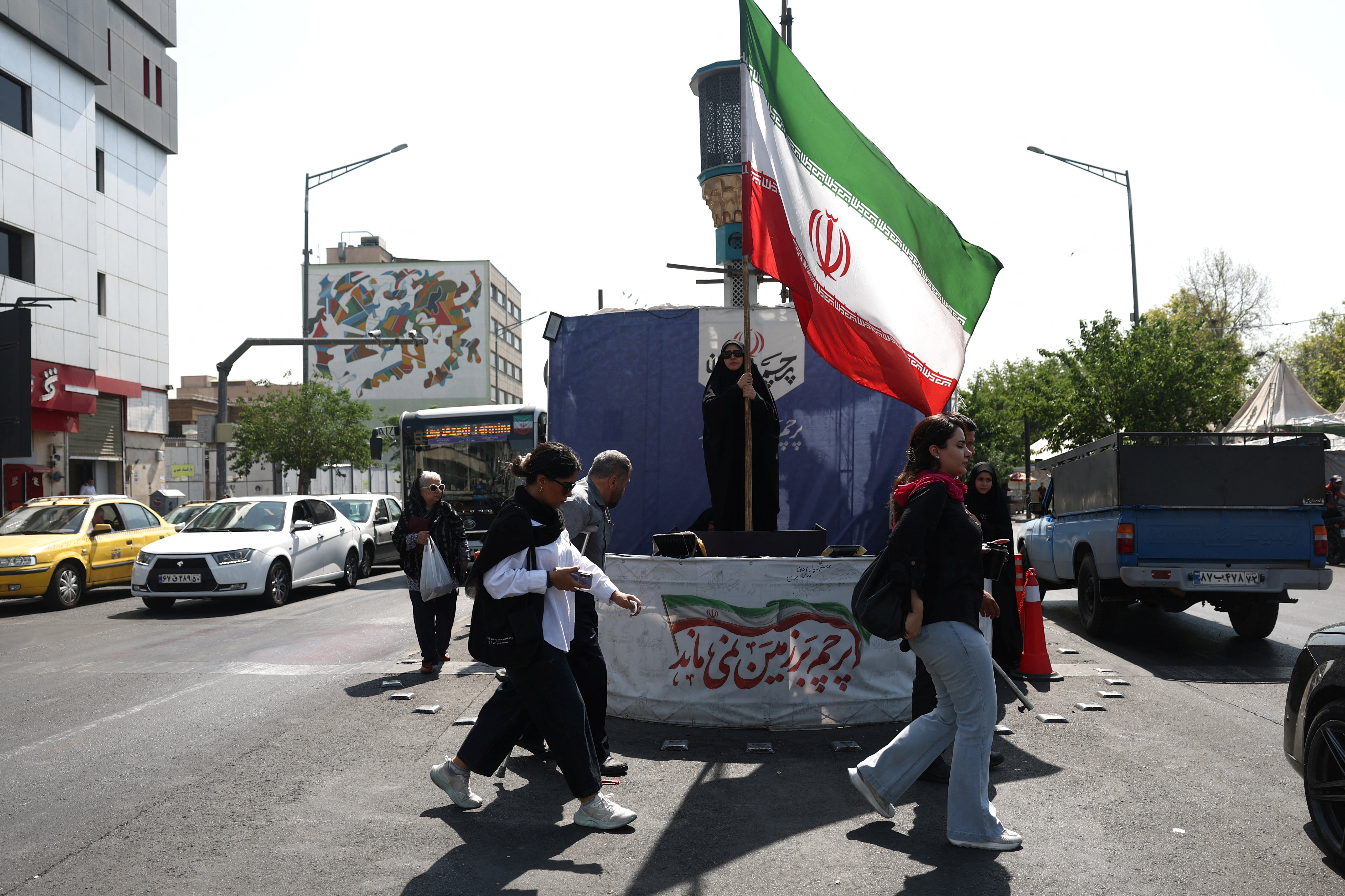 A woman holds an Iranian flag on a street in Tehran, Iran