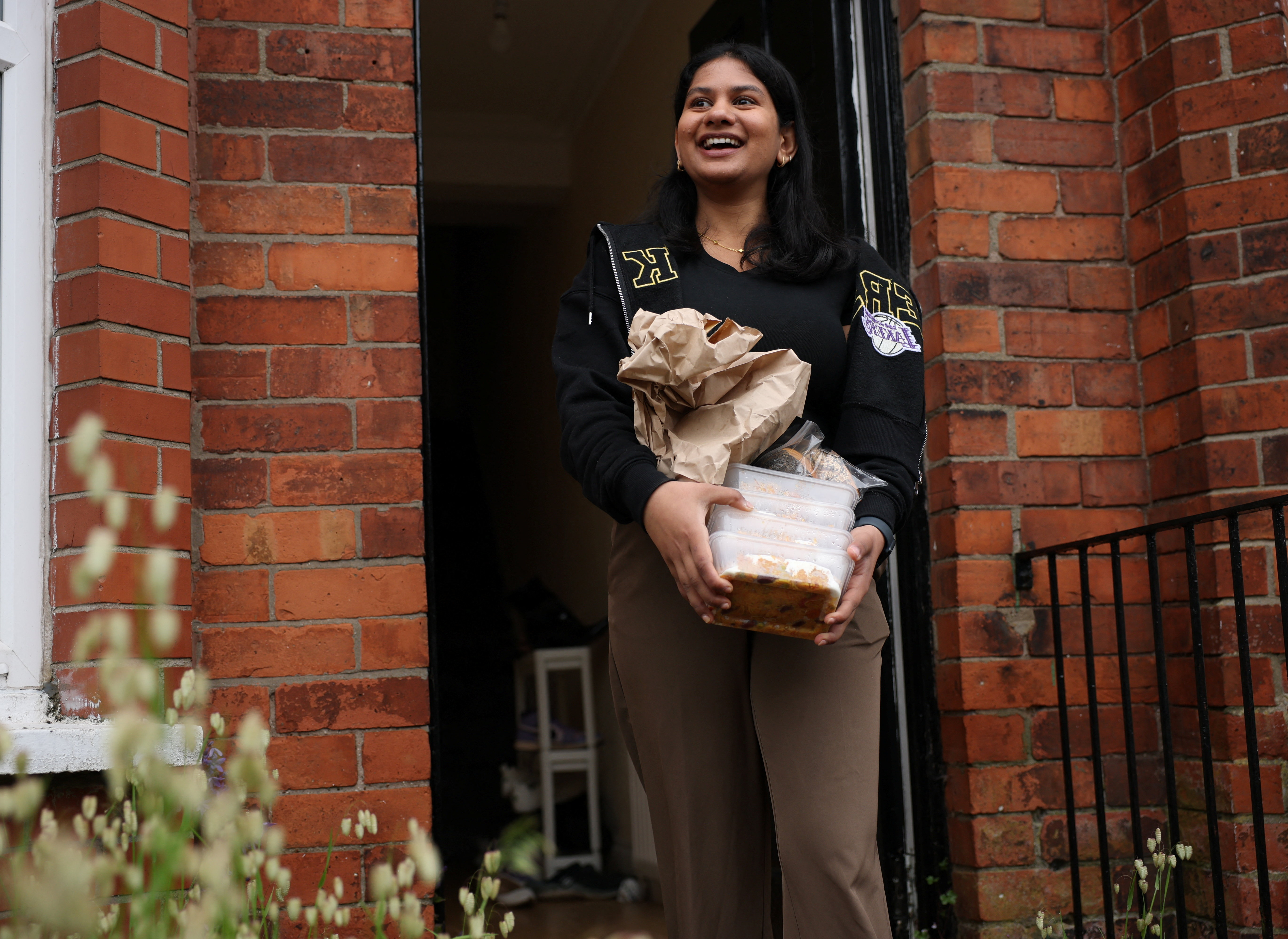 Ruchira Rangaprasad carries food containers to deliver to vulnerable migrants, following a knife attack on June 8, which left a man seriously injured and prompted police to declare it as a critical incident, in Belfast, Northern Ireland, June 11, 2026. REUTERS/Isabel Infantes