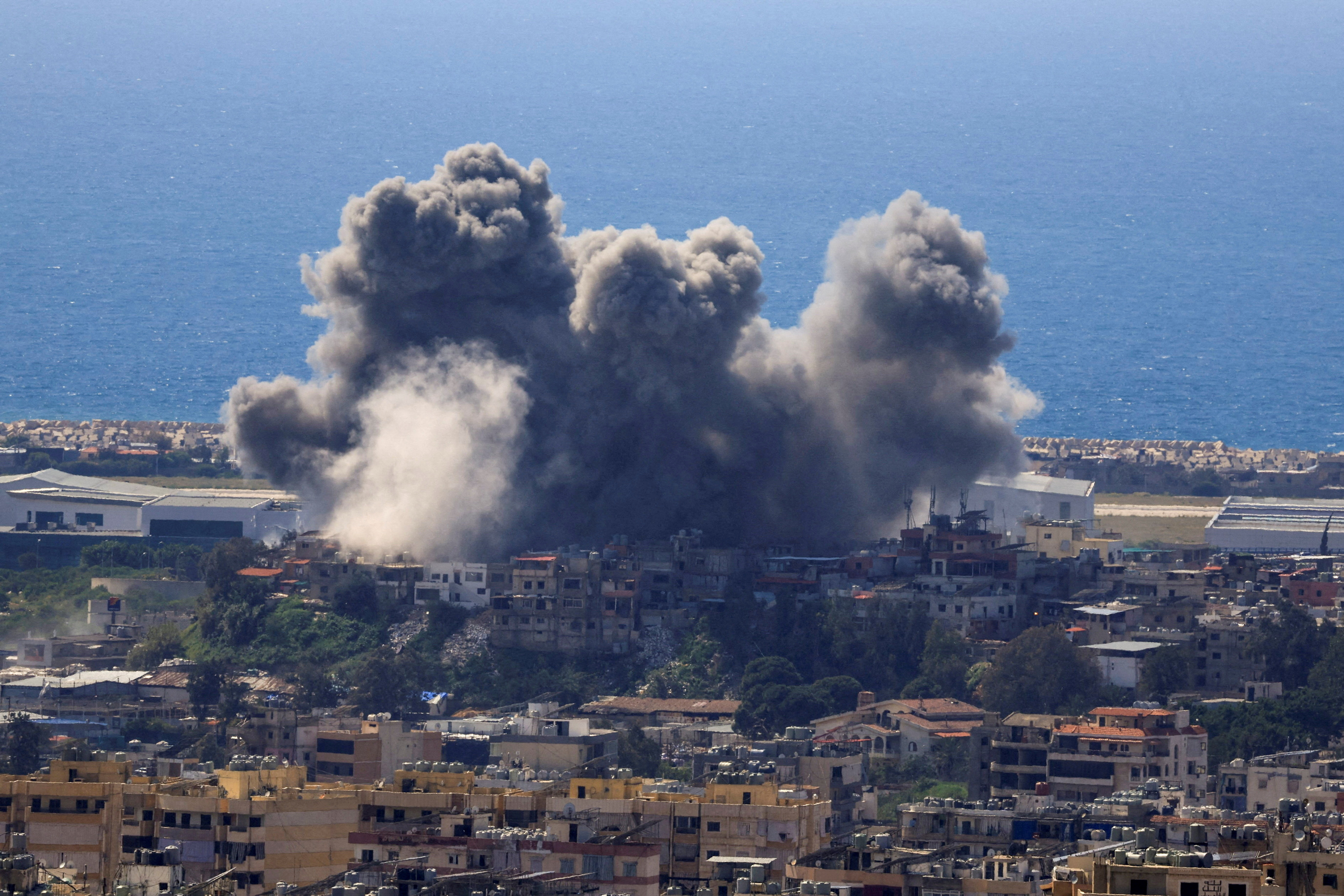 Smoke rises from a town following an air attack.