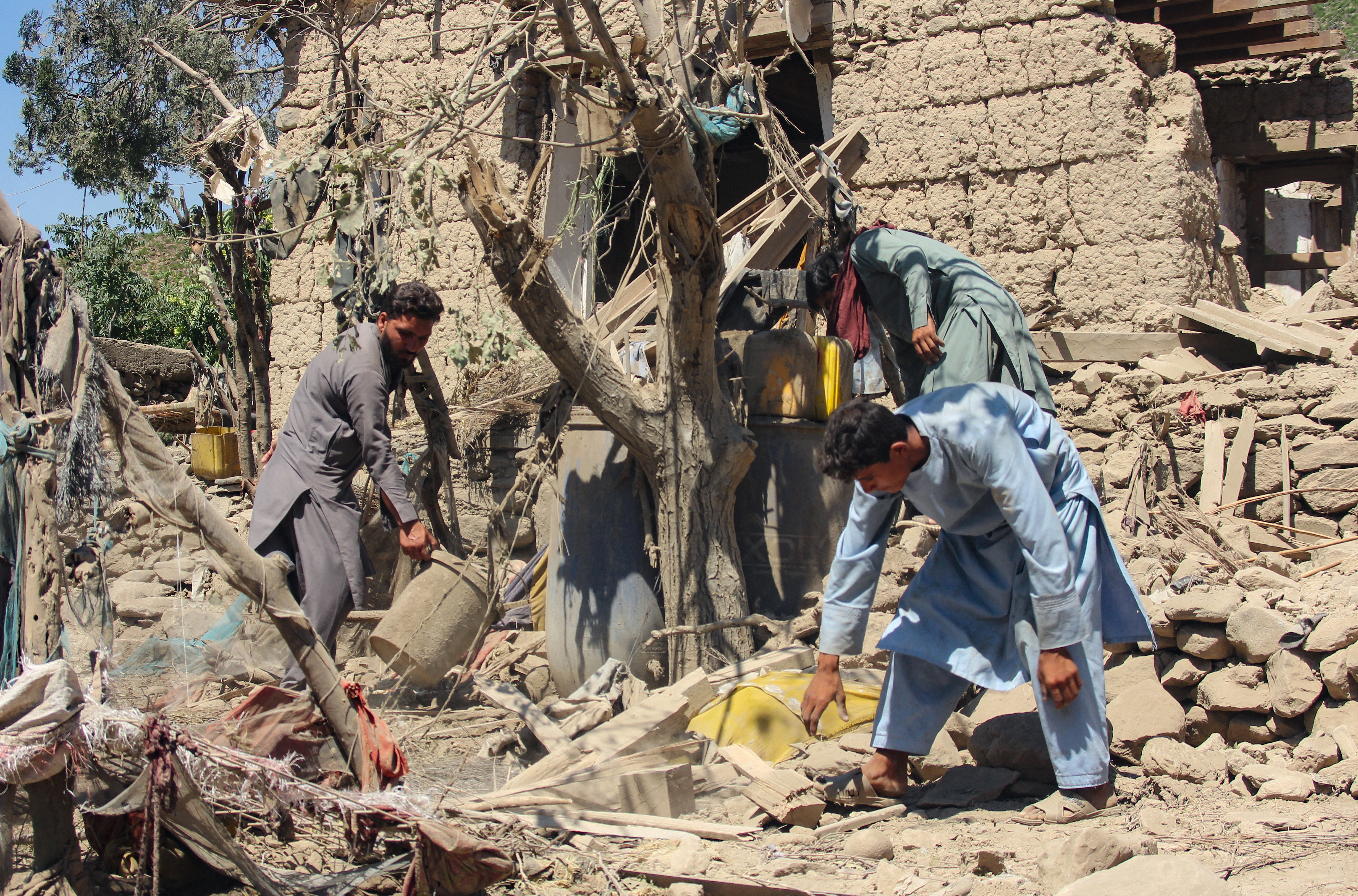 Afghan residents clear the debris of a house damaged by a Pakistani airstrike at Shultan district in Kunar province 