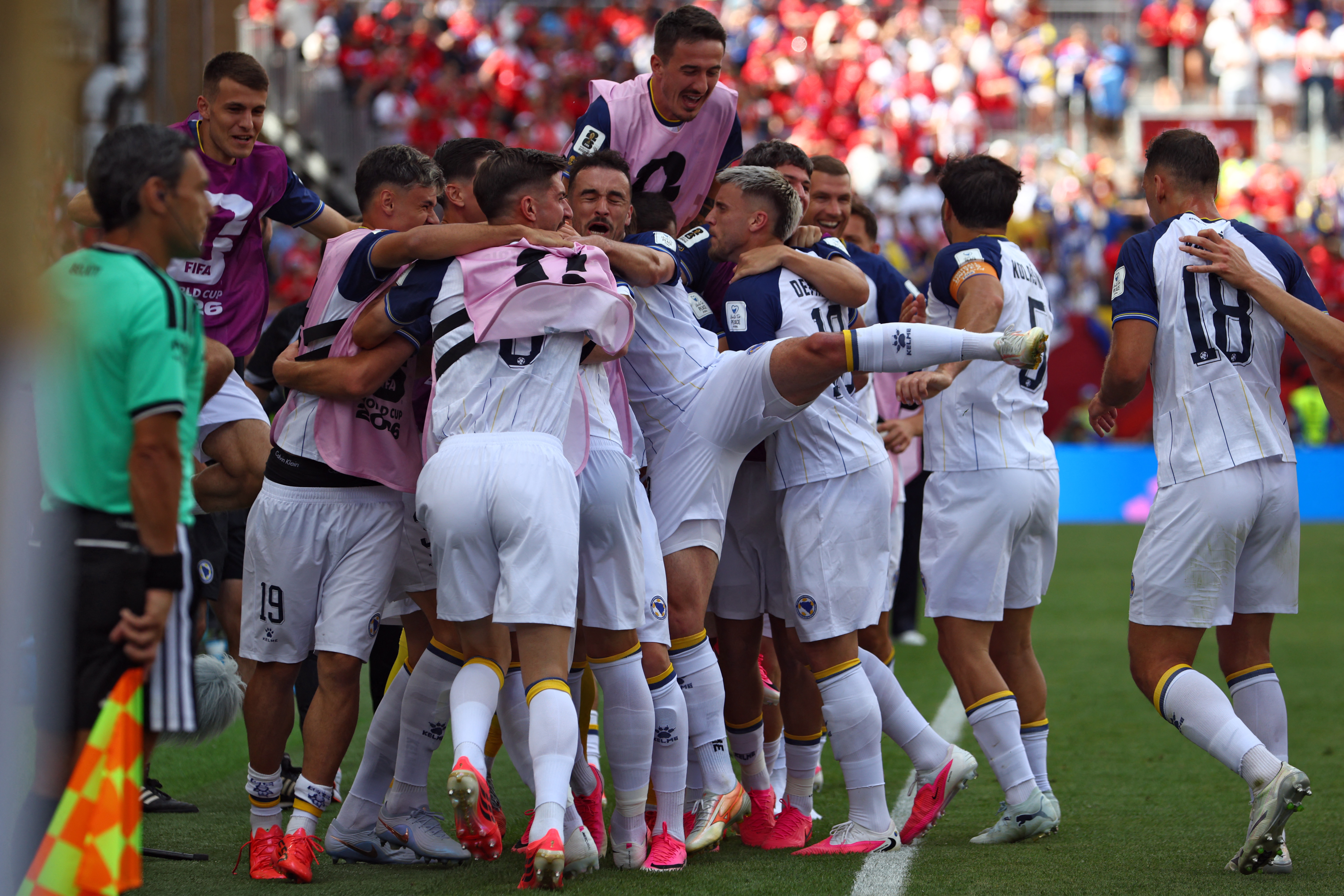 Bosnia-Herzegovina's forward #25 Jovo Lukic (hiddden) is is congratulated by teammates after scoring a goal during the 2026 World Cup Group B football match between Canada and Bosnia and Herzegovina at the Toronto Stadium in Toronto on June 12, 2026. (Photo by Cole Burston / AFP)