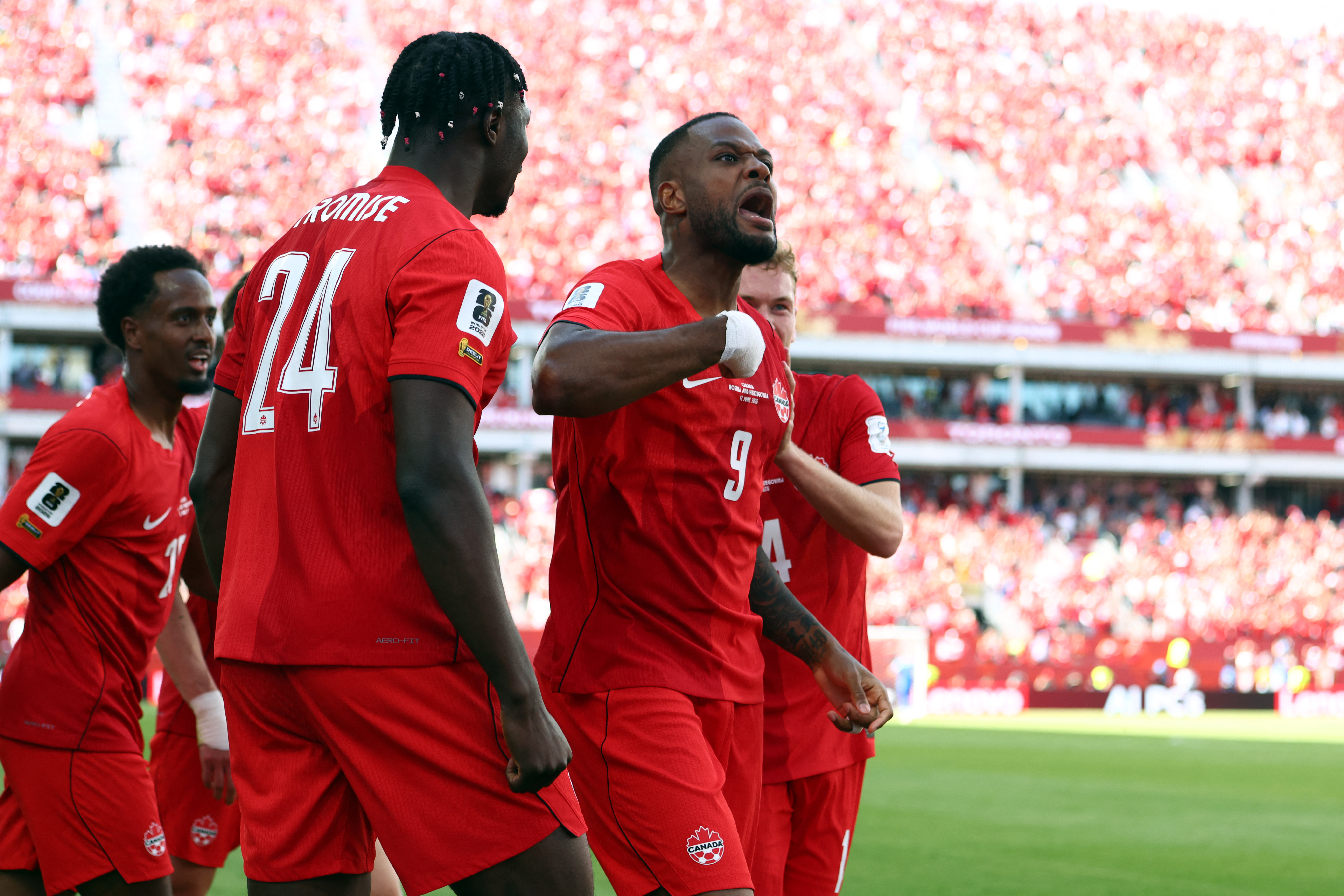 Canada's forward #09 Cyle Larin (R) celebrates after scoring a goal during the 2026 World Cup Group B football match between Canada and Bosnia and Herzegovina at the Toronto Stadium in Toronto on June 12, 2026. (Photo by Cole Burston / AFP)