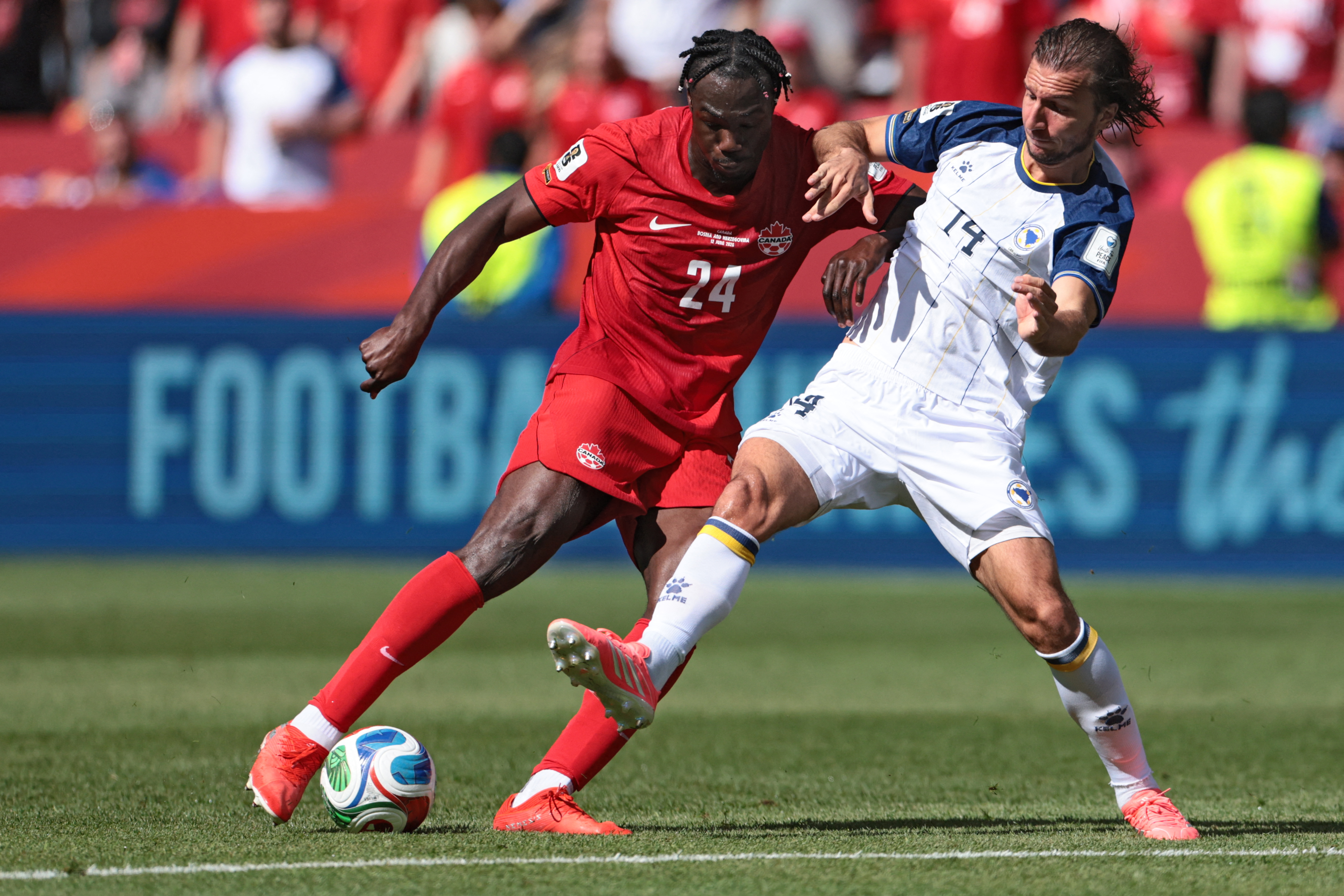 Canada's forward #24 Promise David (L) fights for the ball with Bosnia-Herzegovina's midfielder #14 Ivan Sunjic during the 2026 World Cup Group B football match between Canada and Bosnia and Herzegovina at the Toronto Stadium in Toronto on June 12, 2026. (Photo by Cole Burston / AFP)