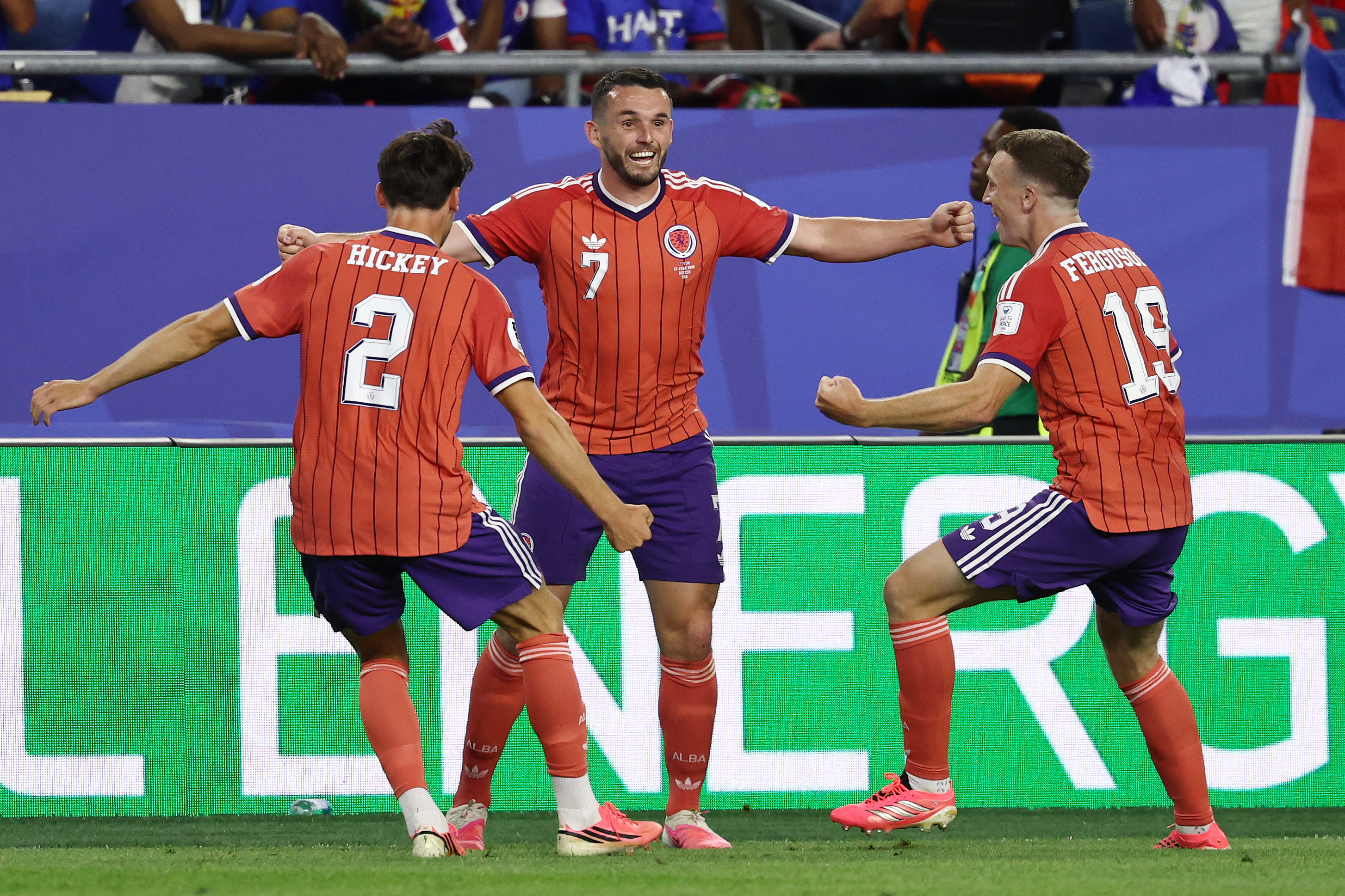 Scotland's midfielder #07 John McGinn celebrates with teammates defender #02 Aaron Hickey and midfielder #19 Lewis Ferguson after scoring his team's first goal during the 2026 World Cup Group C football match between Haiti and Scotland at the Boston Stadium in Foxborough on June 13, 2026. (Photo by FRANCK FIFE / AFP)