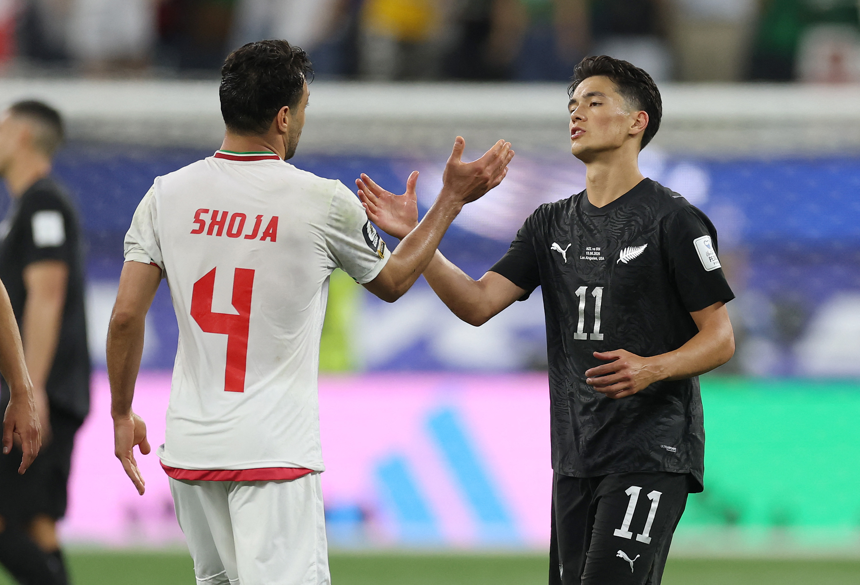 LOS ANGELES, CALIFORNIA - JUNE 15: Shoja Khalilzadeh #4 of IR Iran and Elijah Just #11 of New Zealand shakes hands after the 2-2 draw in the FIFA World Cup 2026 Group G match between IR Iran and New Zealand at Los Angeles Stadium on June 15, 2026 in Los Angeles, California. Jamie Squire/Getty Images/AFP (Photo by JAMIE SQUIRE / GETTY IMAGES NORTH AMERICA / Getty Images via AFP)