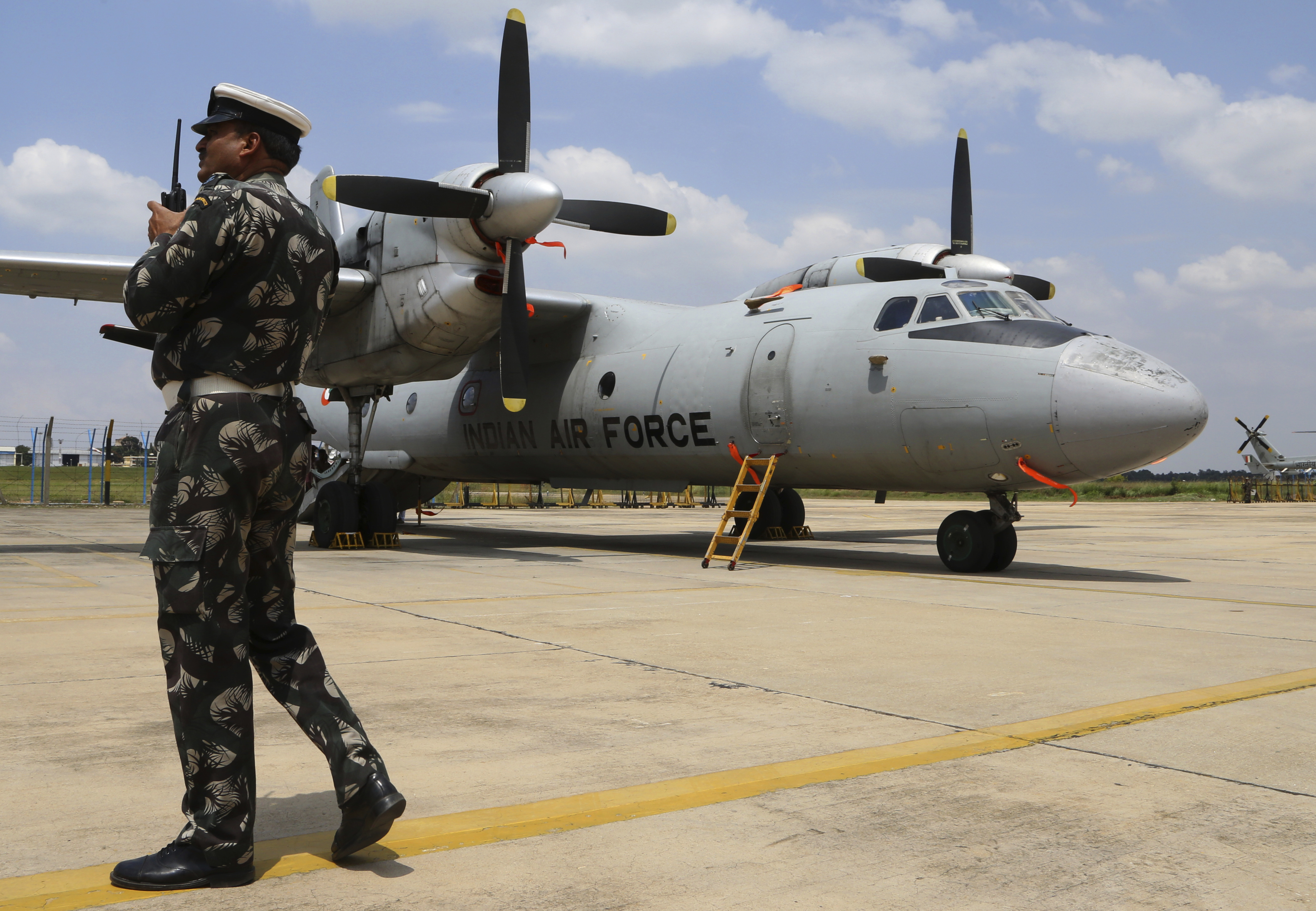 An Indian Air Force (IAF) official talks on his radio transmitter next to the Antonov AN-32 twin engine turboprop transport aircraft at an air base ahead of the Air Force Day celebrations in Bangalore, India, Tuesday, Oct. 4, 2016. The IAF was established on Oct. 8, 1932 and is the fourth largest air force in the world.