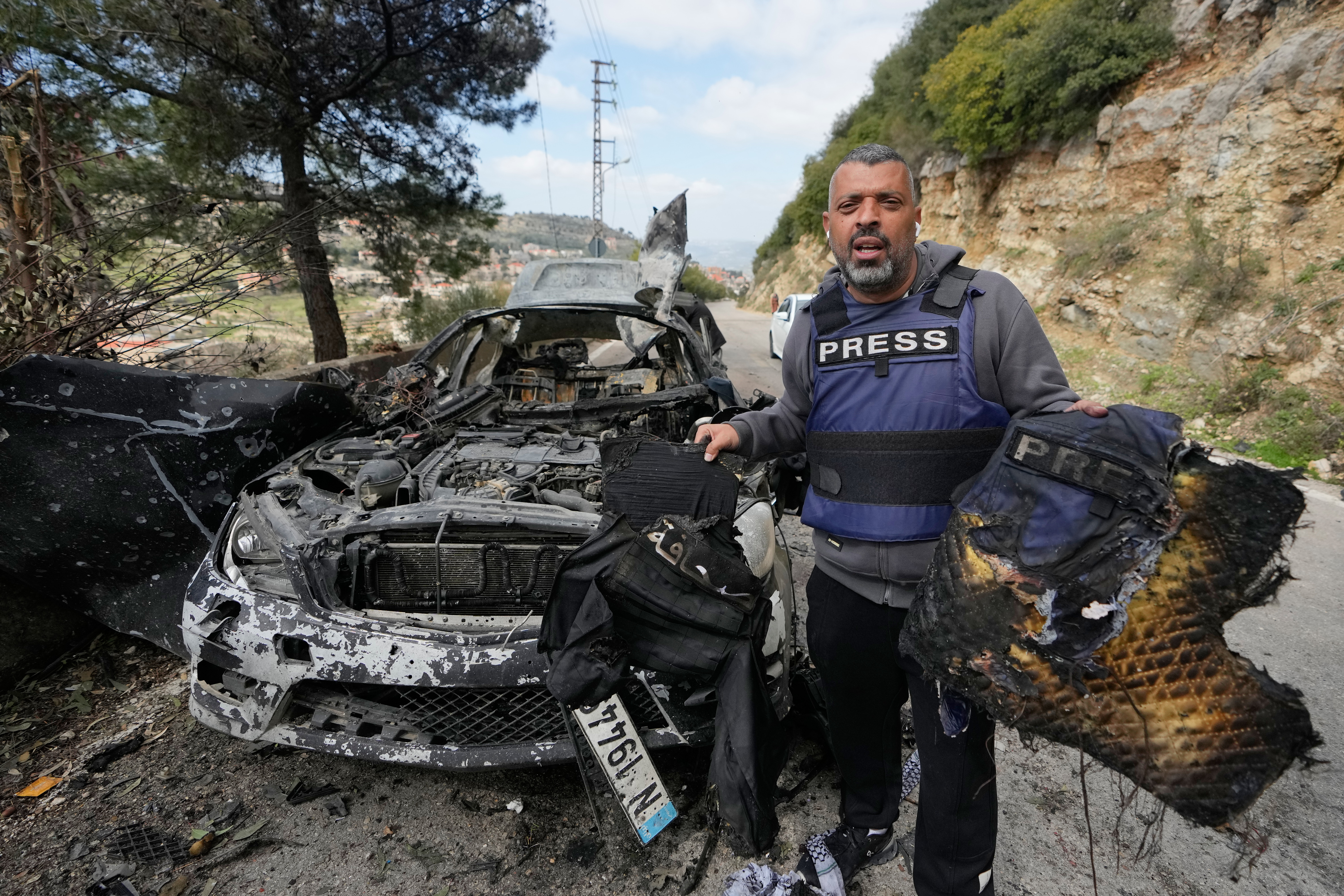 A journalist carries burned safety gear, following an Israeli airstrike on a car that killed Hezbollah's al-Manar TV correspondent Ali Shoeib, Beirut's based Al-Mayadeen TV reporter Fatima Ftouni and her brother, video journalist Mohammed Ftouni, in the town of Jezzine, south Lebanon, Saturday, March 28, 2026. (AP Photo/Mohammed Zaatari)