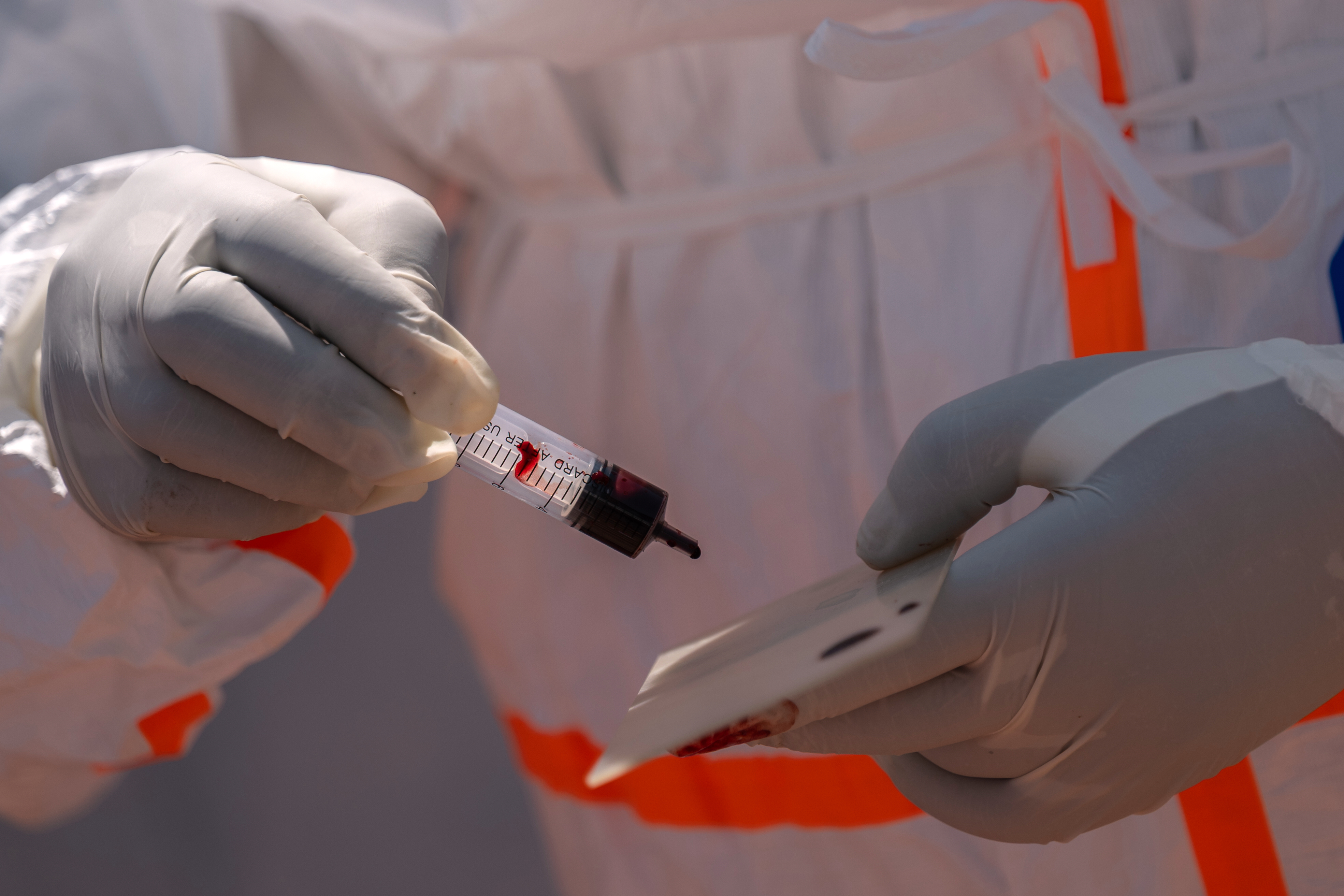 A health worker prepares a patient's blood sample for testing.