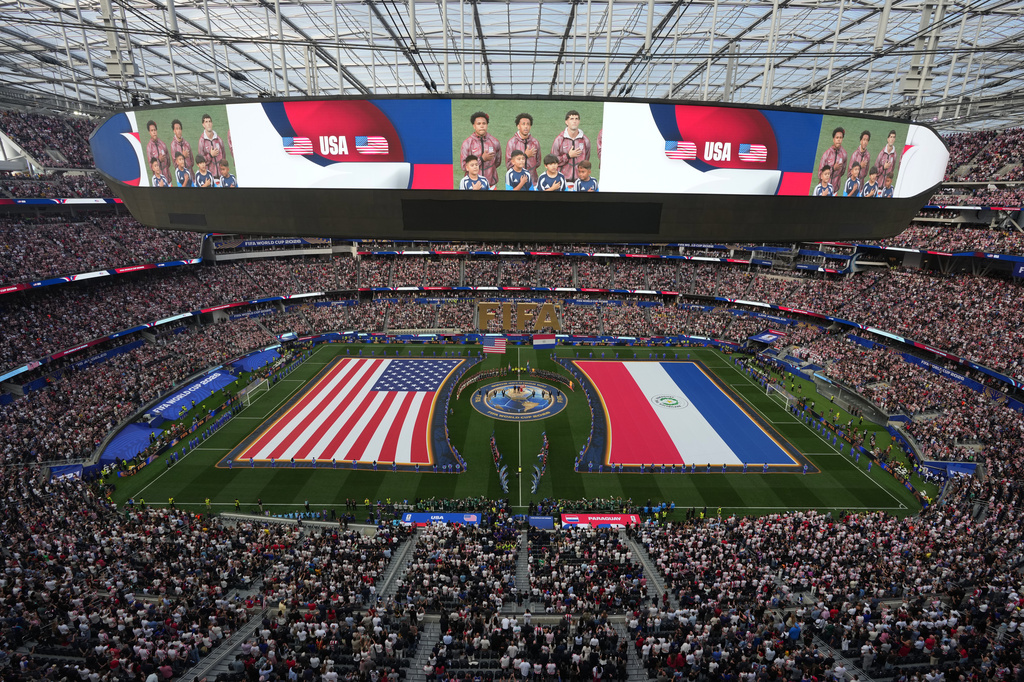 US and Paraguay flags on the turf of stadium