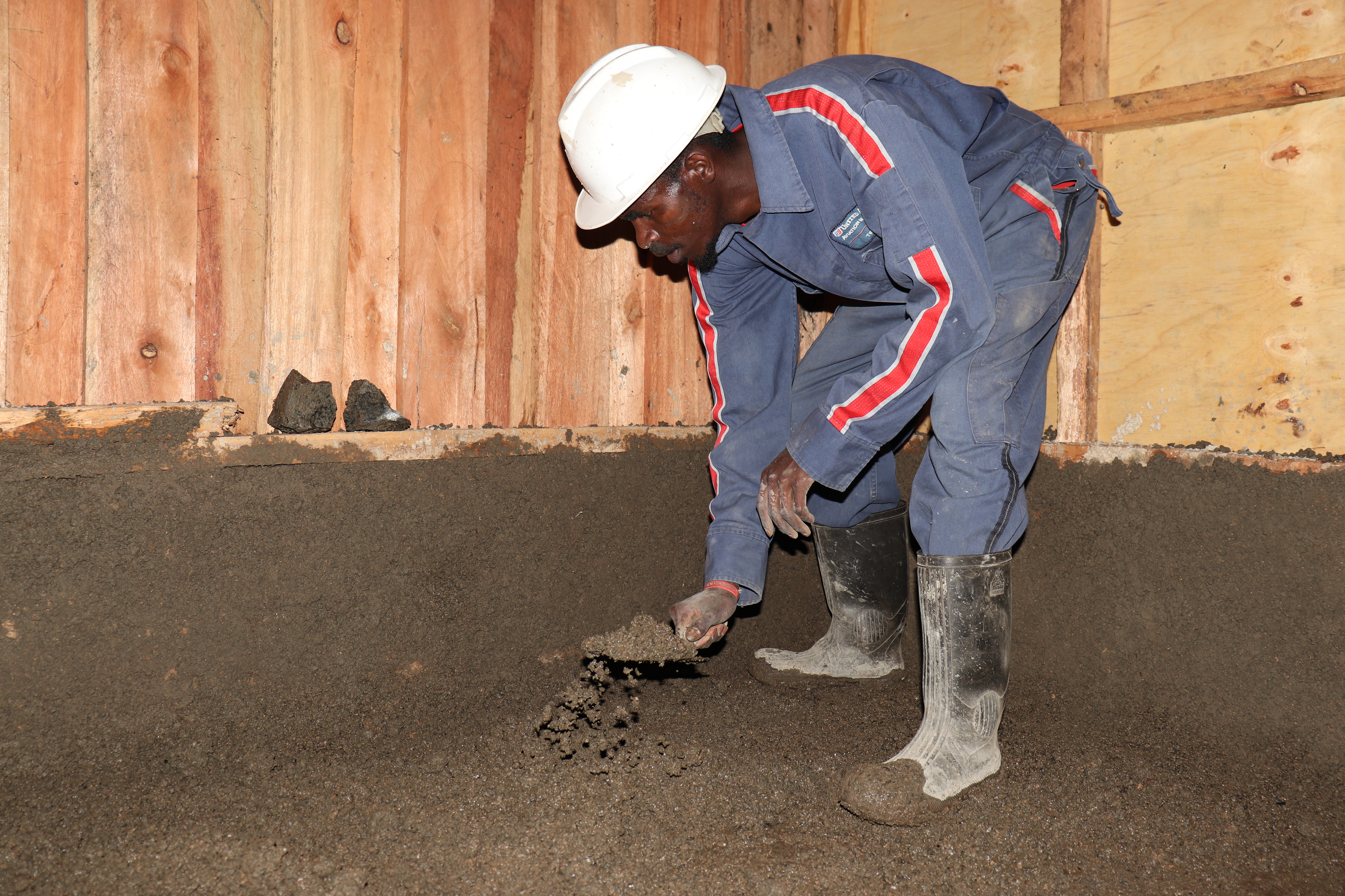 Kiplang’at uses mortar to build a wall