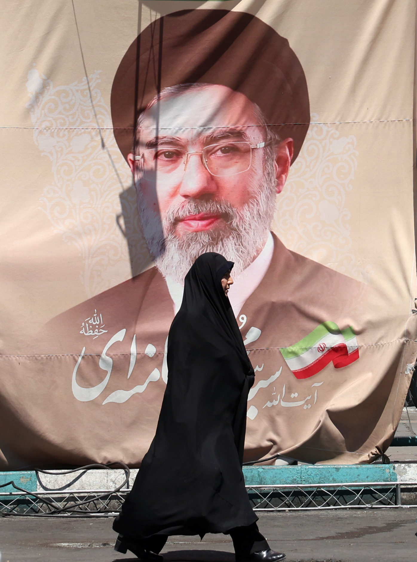 epa13038368 A veiled Iranian woman walks past a billboard of Iranian supreme leader Ayatollah Mojtaba Khamenei at Valiasr Square in Tehran, Iran, 15 June 2026. US President Donald Trump announced on his social media platform that a deal with Iran has been reached and is set to be signed on 19 June in Switzerland. EPA/ABEDIN TAHERKENAREH RESTRICTIONS: NO Access Israel Media/Persian Language TV Stations Outside Iran/Strictly No Access BBC Persian/VOA Persian/Manoto TV/Iran International TV. (As mandated by Iran's Directorate General for Foreign Media) --