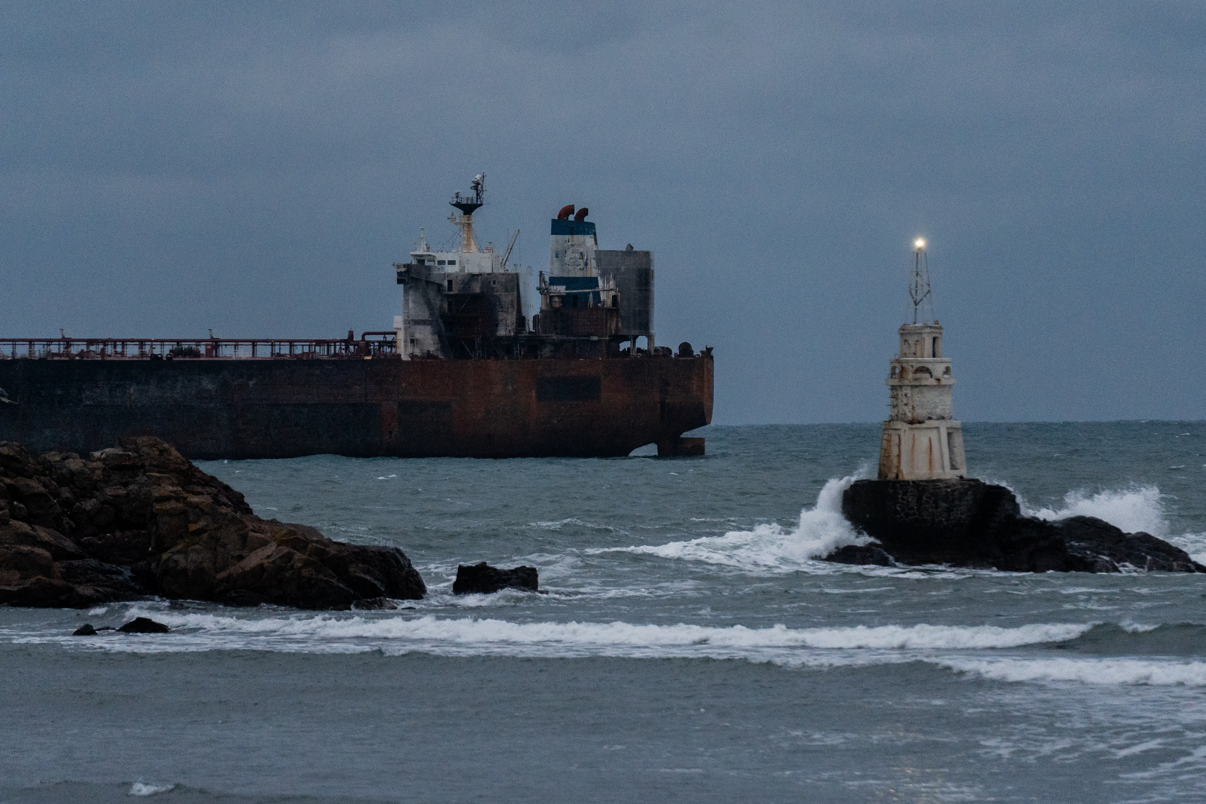 AHTOPOL, BULGARIA - DECEMBER 8: The Kairos oil tanker, a Gambian-flagged vessel believed to be part of Russia's shadow fleet, remains anchored on December 8, 2025 in Ahtopol, Bulgaria. Last week, the ship was sailing from Egypt toward the Russian port of Novorossiysk when it caught fire after an alleged attack by Ukrainian naval drones. Bulgarian maritime authorities are planning the evacuation of the remaining crew. The tanker was sanctioned by the European Union in July for its involvement in Russia's so-called shadow fleet, a clandestine network of vessels that help the country skirt price-capping sanctions on Russian oil sales, penalties that were imposed after the 2022 invasion of Ukraine. (Photo by Hristo Rusev/Getty Images)