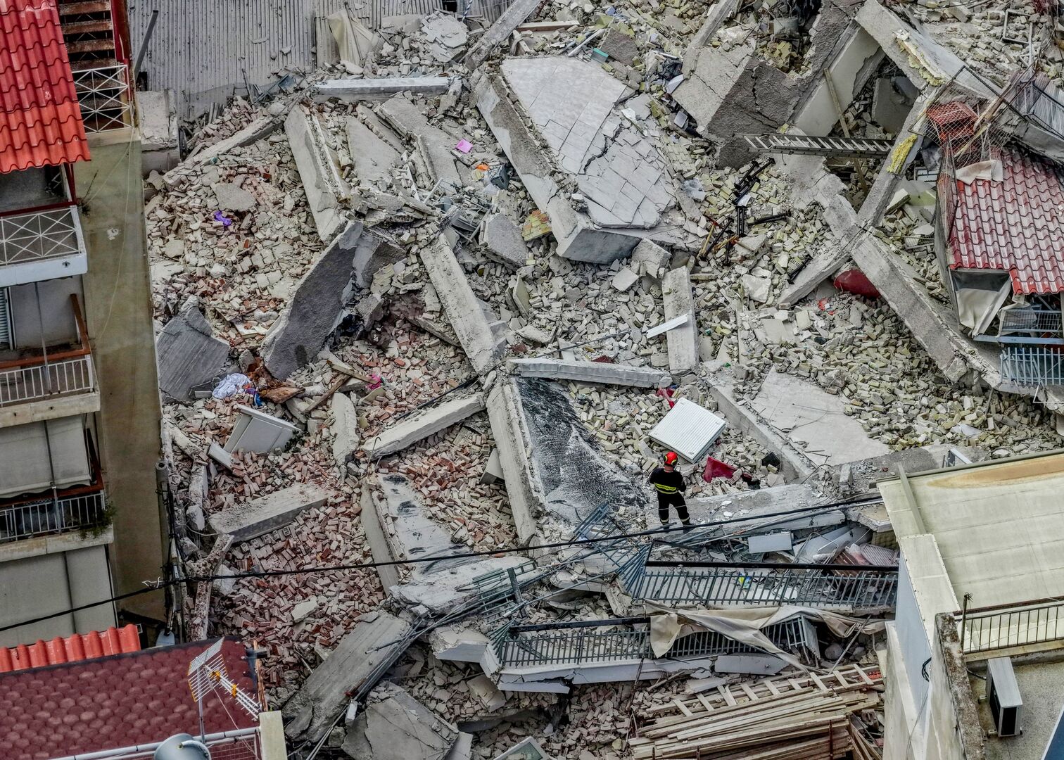 A drone view of emergency personnel looking for people trapped under the rubble at the site of a building collapse in the Petralona neighbourhood of Athens, Greece, June 30, 2026. [Stringer/Eurokinissi/Reuters}