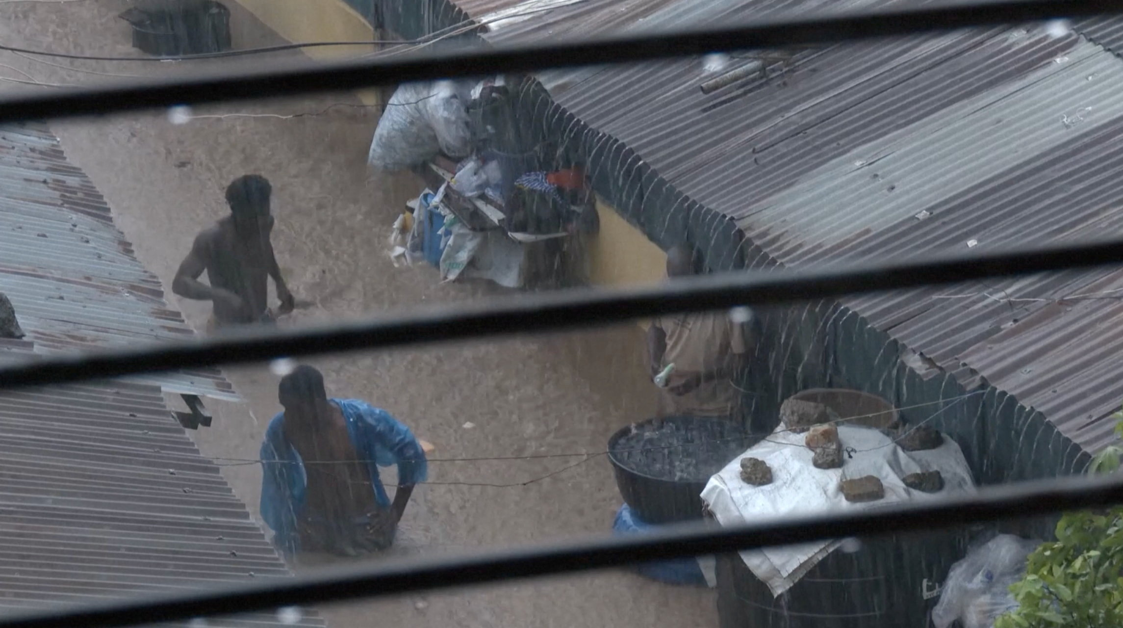 People wade through floodwaters, in Accra, Ghana, in this still image taken from a video, June 29, 2026 [Reuters TV via Reuters]