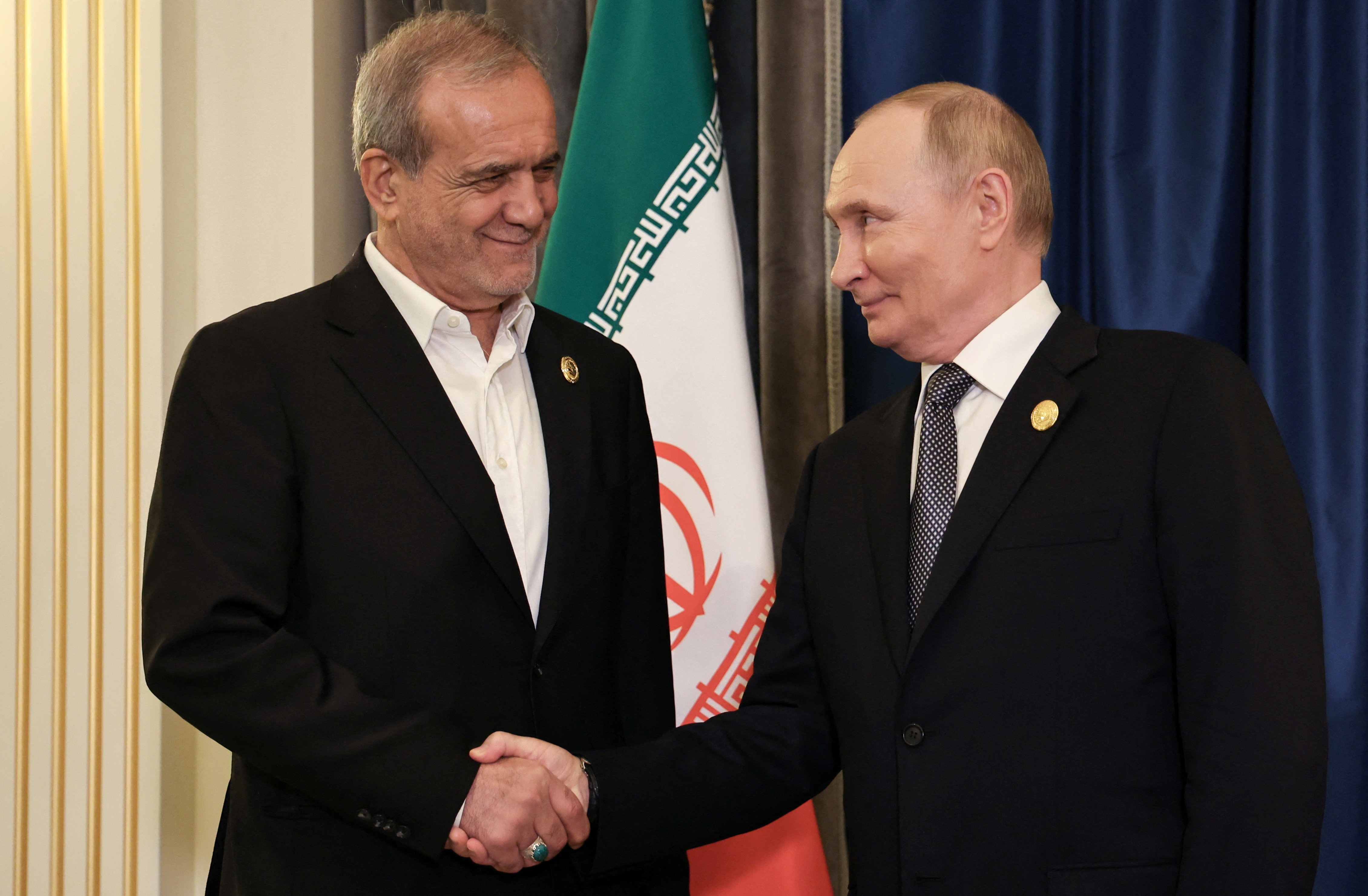 Russia's President Vladimir Putin shakes hands with Iran's President Masoud Pezeshkian