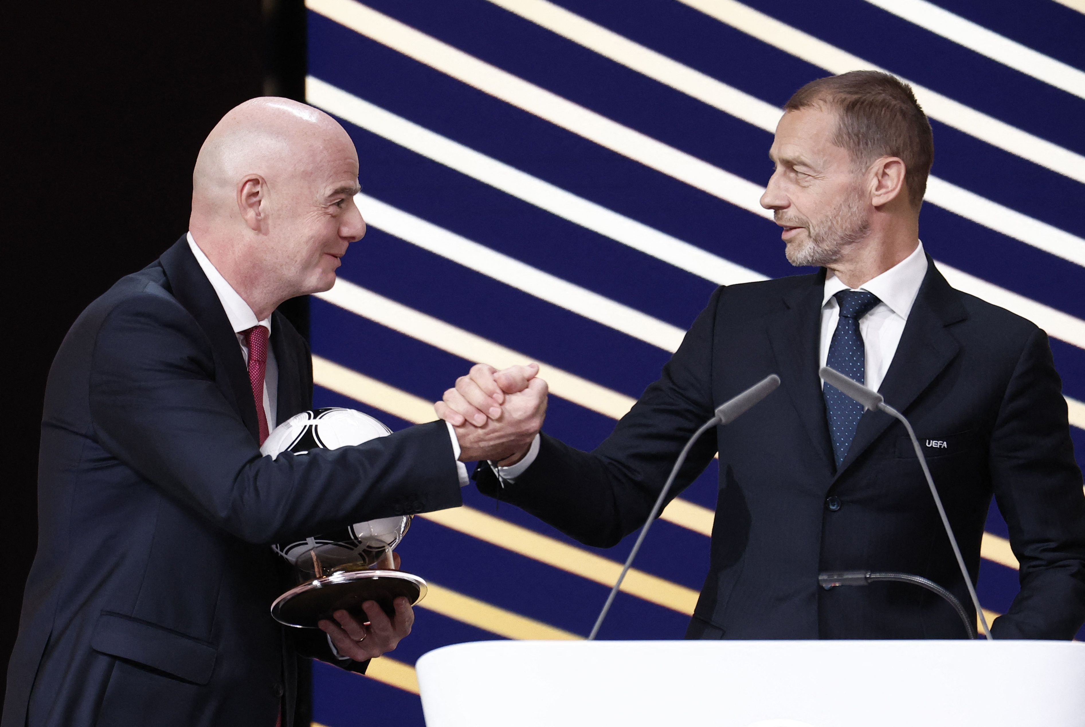 UEFA president Aleksander Ceferin (right) and FIFA president Gianni Infantino shake hands.