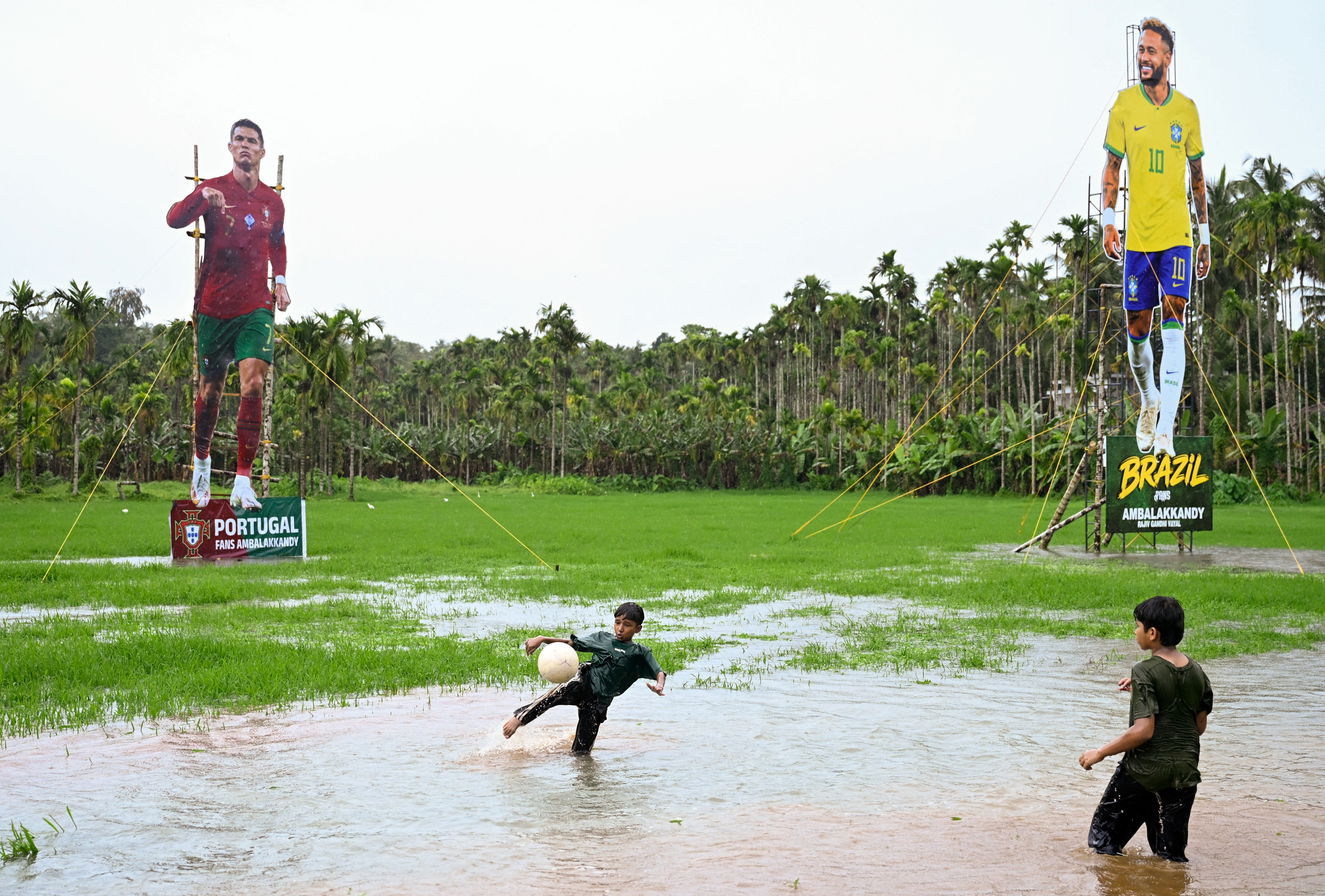 Children play football in front of cutouts of Portugal’s Cristiano Ronaldo and Brazil’s Neymar Jr put up by supporters ahead of the 2026 FIFA World Cup, in Kozhikode, India, on June 9, 2026