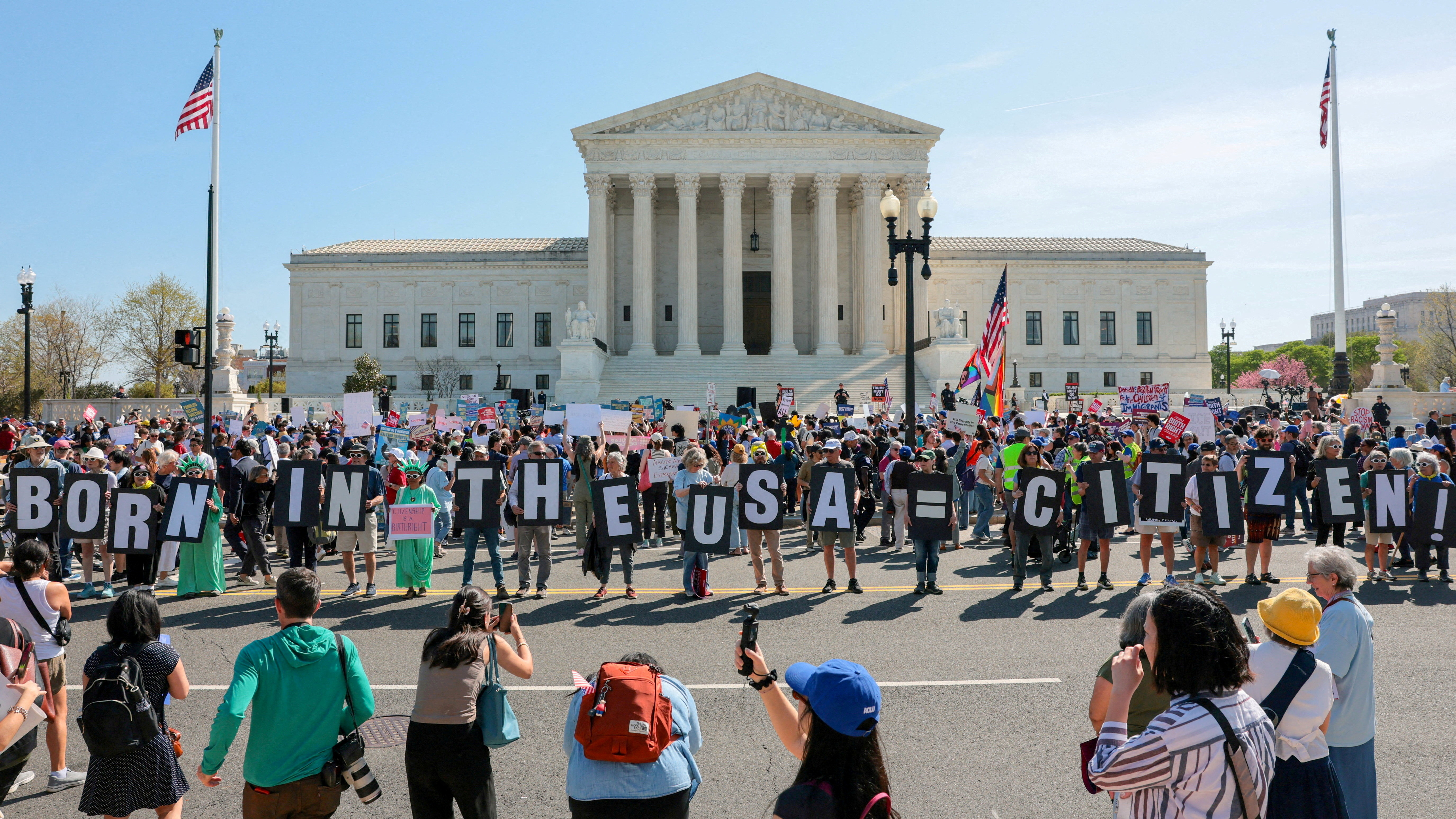 Demonstrators hold letters making up the slogan "Born in the USA = citizen!" outside the U.S. Supreme Court building