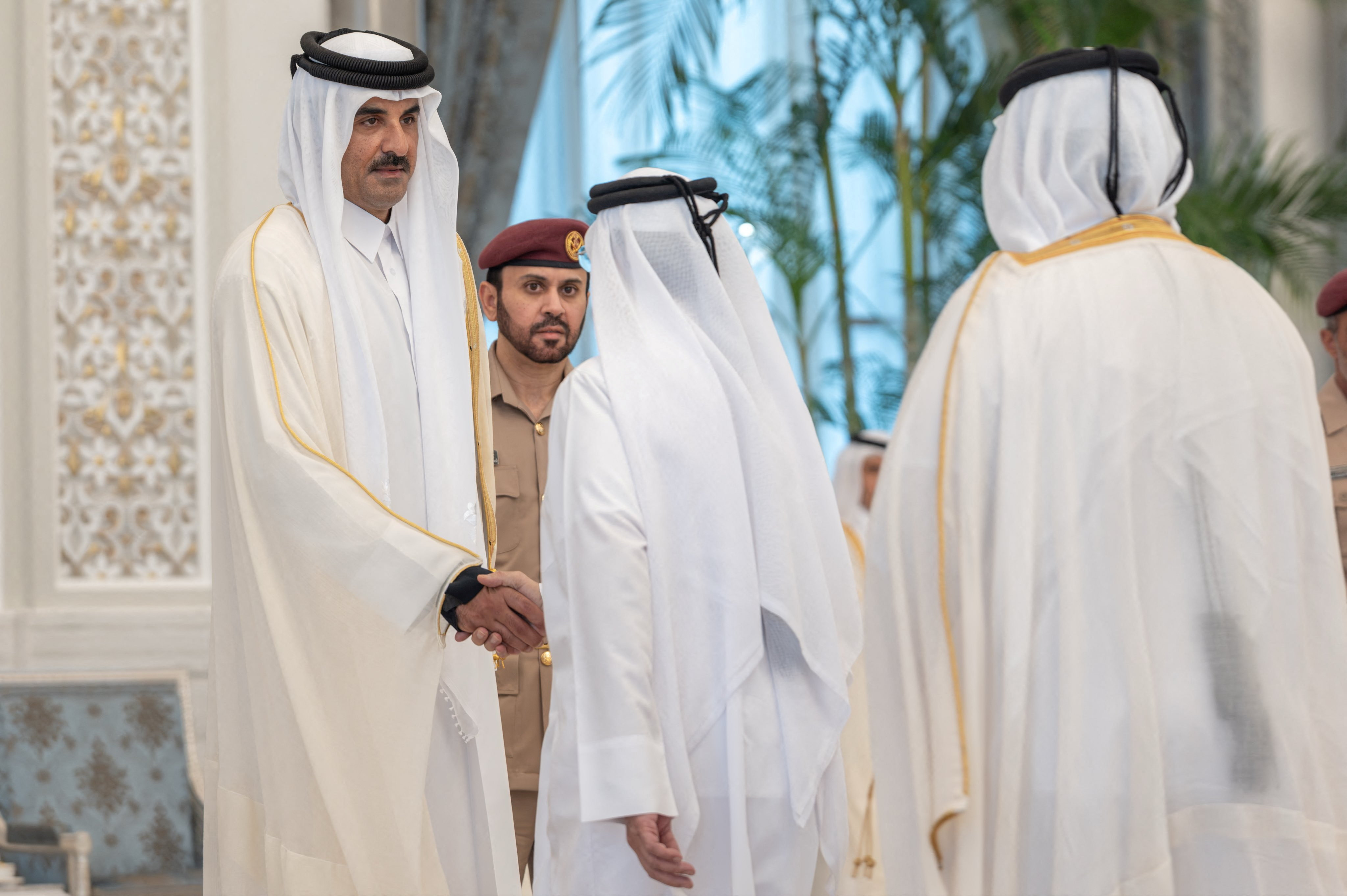 Qatar's Emir Sheikh Tamim bin Hamad Al Thani shakes hands with a mourner as he receives condolences.
