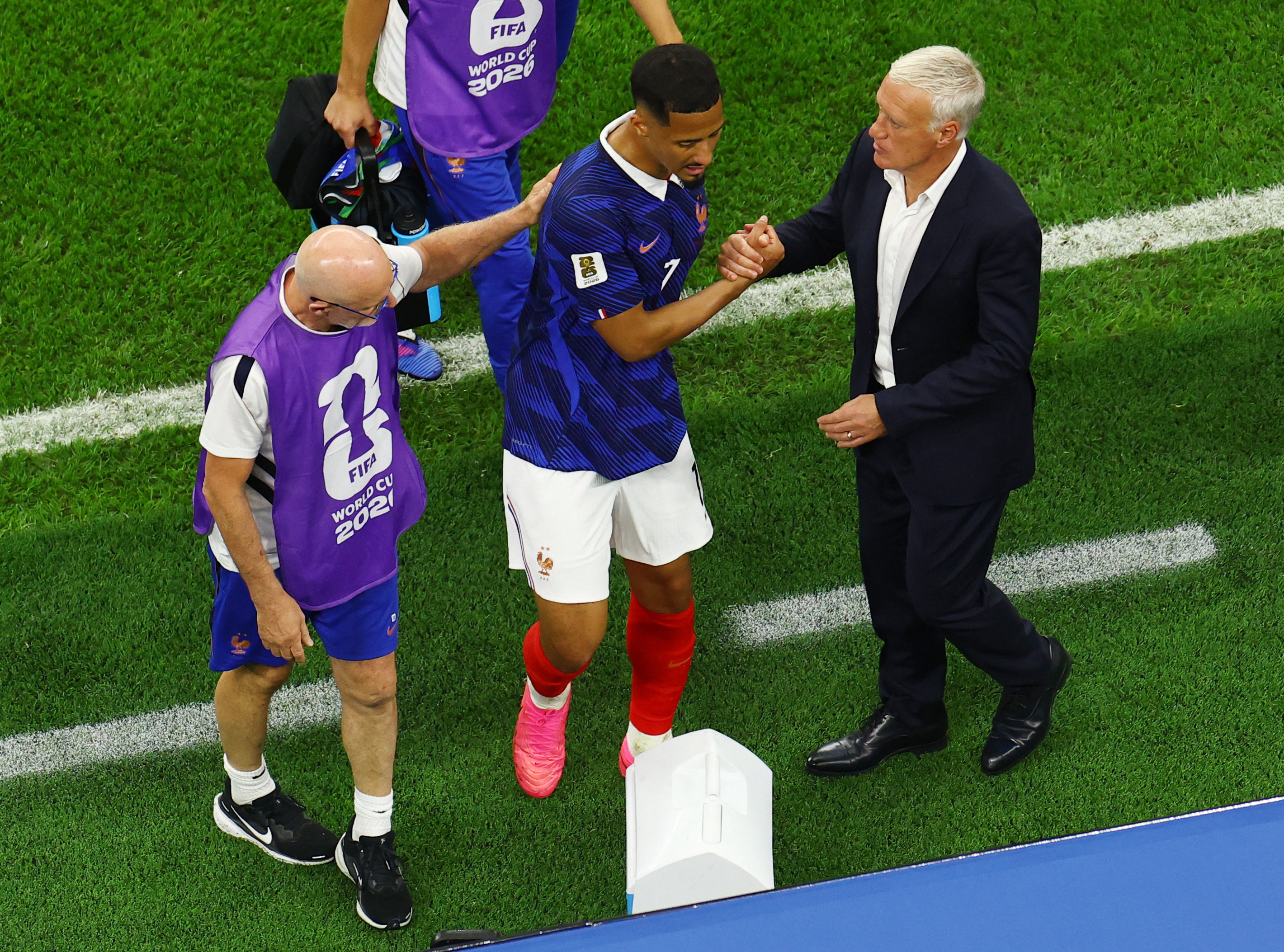 Soccer Football - FIFA World Cup 2026 - Semi Final - France v Spain - Dallas Stadium, Arlington, Texas, U.S. - July 14, 2026 France's William Saliba shakes hands with coach Didier Deschamps after sustaining an injury and being escorted off the pitch REUTERS/Marco Bello