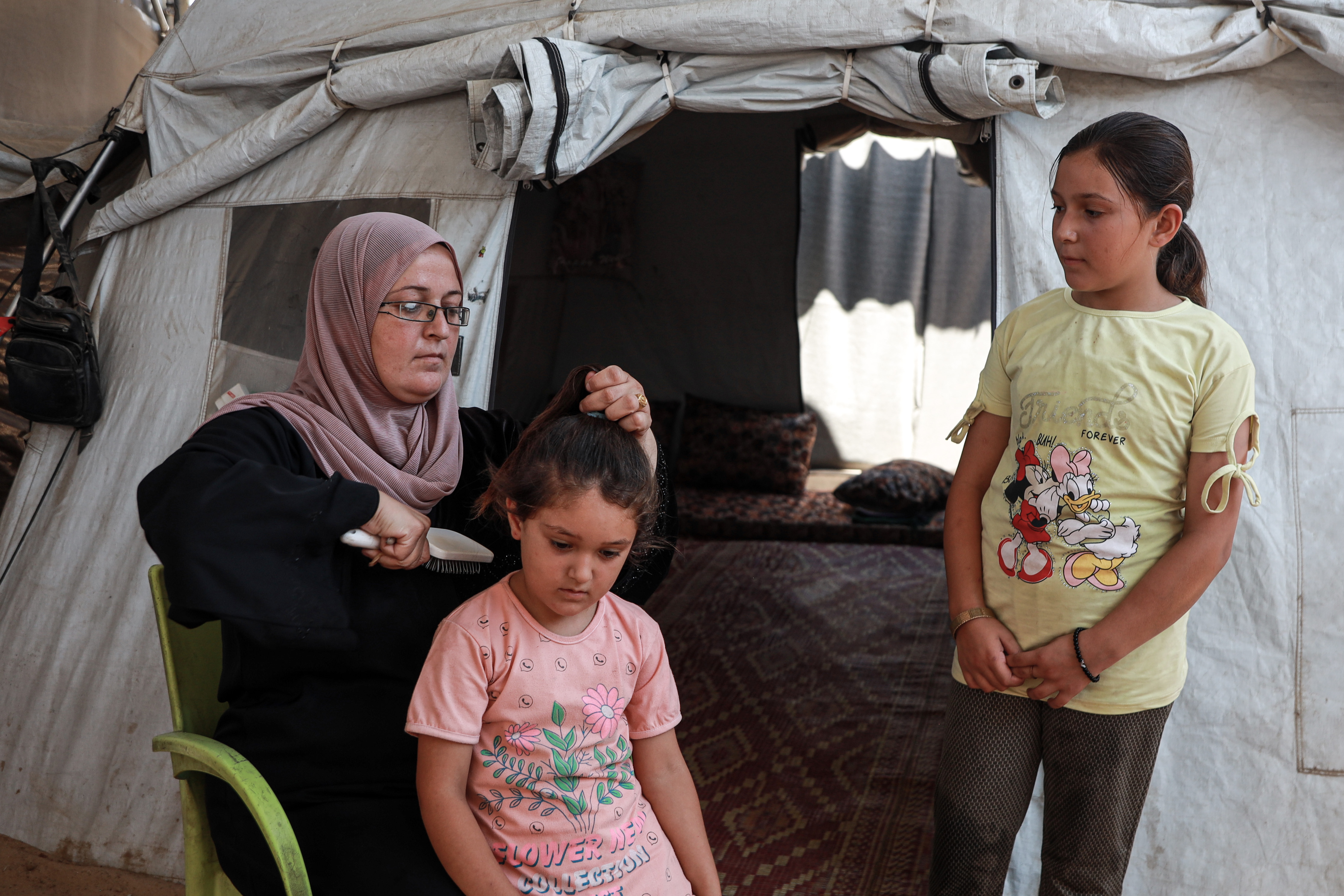 A mother of five, Alaa cares for her children alone. She is pictured with her daughters Sham, 5, and Maria, 10 [Abdelhakim Abu Riash/Al Jazeera]