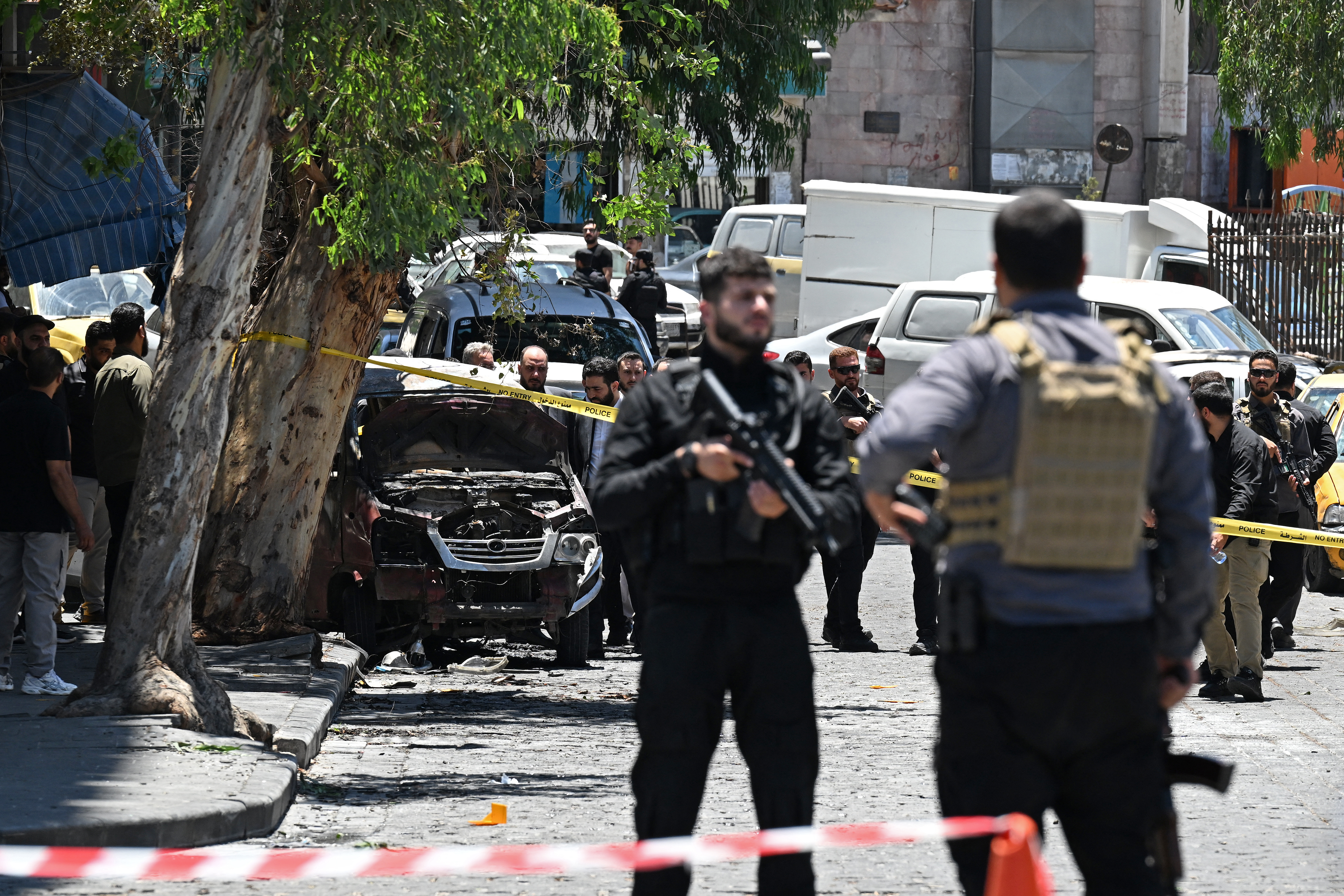 Security personnel stand guard near the Four Seasons Hotel following two blasts nearby in Damascus on July 7, 2026. Two explosions shook Damascus on July 7 near a hotel where French President Emmanuel Macron was staying, wounding at least 18 people, during the French leader's landmark visit to Syria. (Photo by LOUAI BESHARA / AFP)