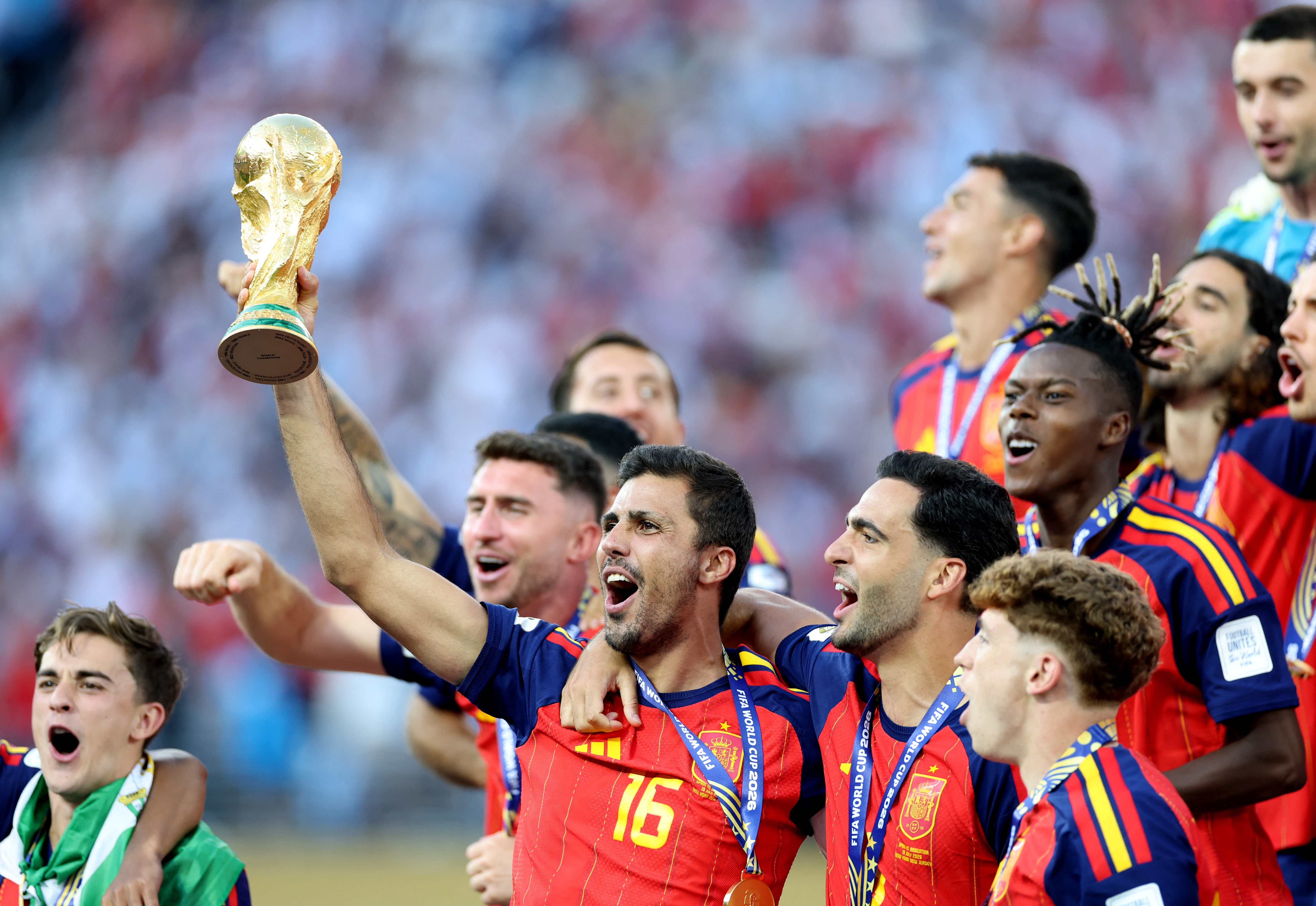 EAST RUTHERFORD, NEW JERSEY - JULY 19: Rodri #16 of Spain lifts the FIFA World Cup Winners Trophy after the teams victory following the FIFA World Cup 2026 Final match between Spain and Argentina at New York New Jersey Stadium on July 19, 2026 in East Rutherford, New Jersey. Dan Mullan/Getty Images/AFP (Photo by Dan Mullan / GETTY IMAGES NORTH AMERICA / Getty Images via AFP)