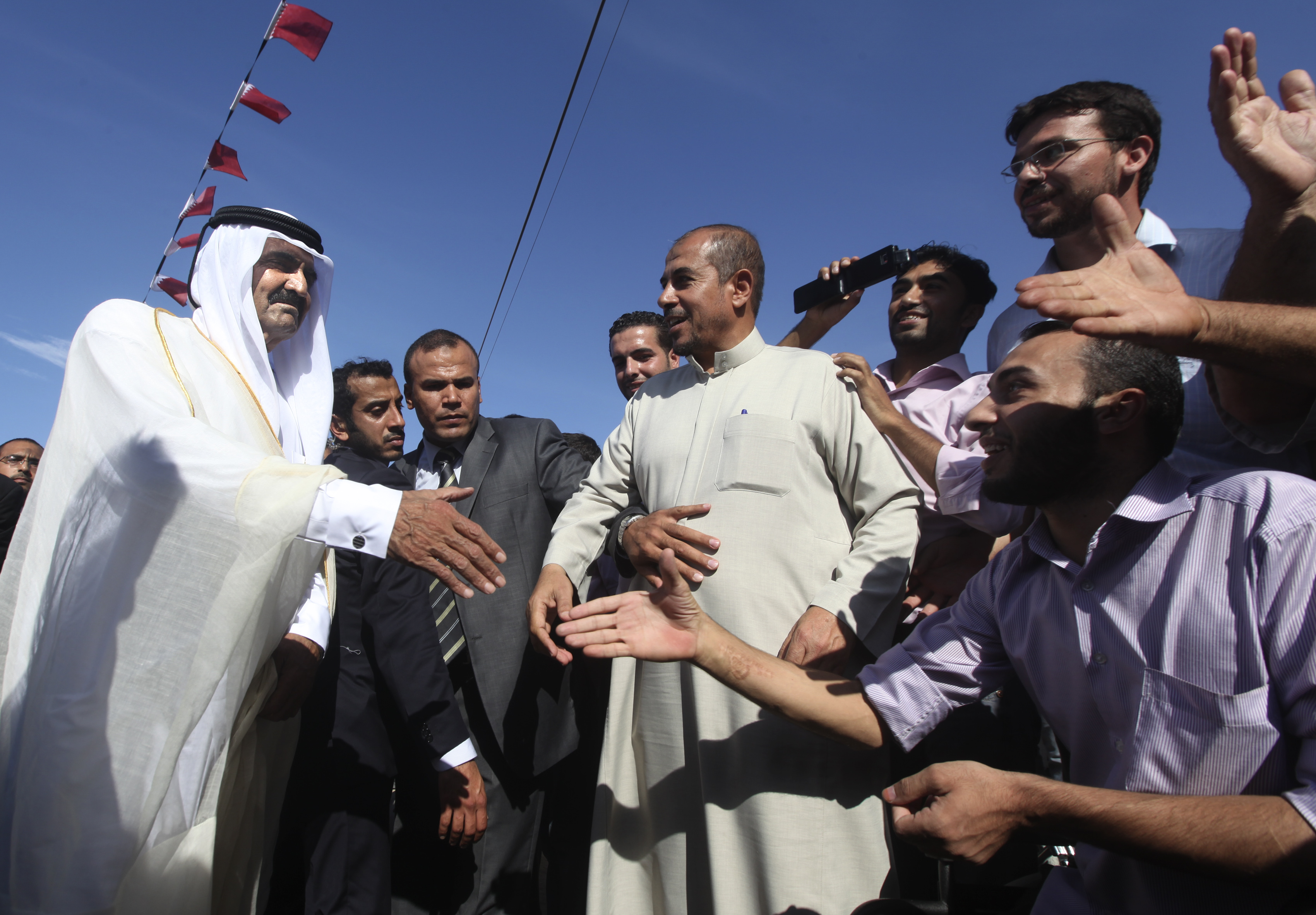 The late Emir of Qatar greets people in Gaza City as he arrives for a cornerstone-laying ceremony at a Qatari-funded rehabilitation centre, October 23, 2012