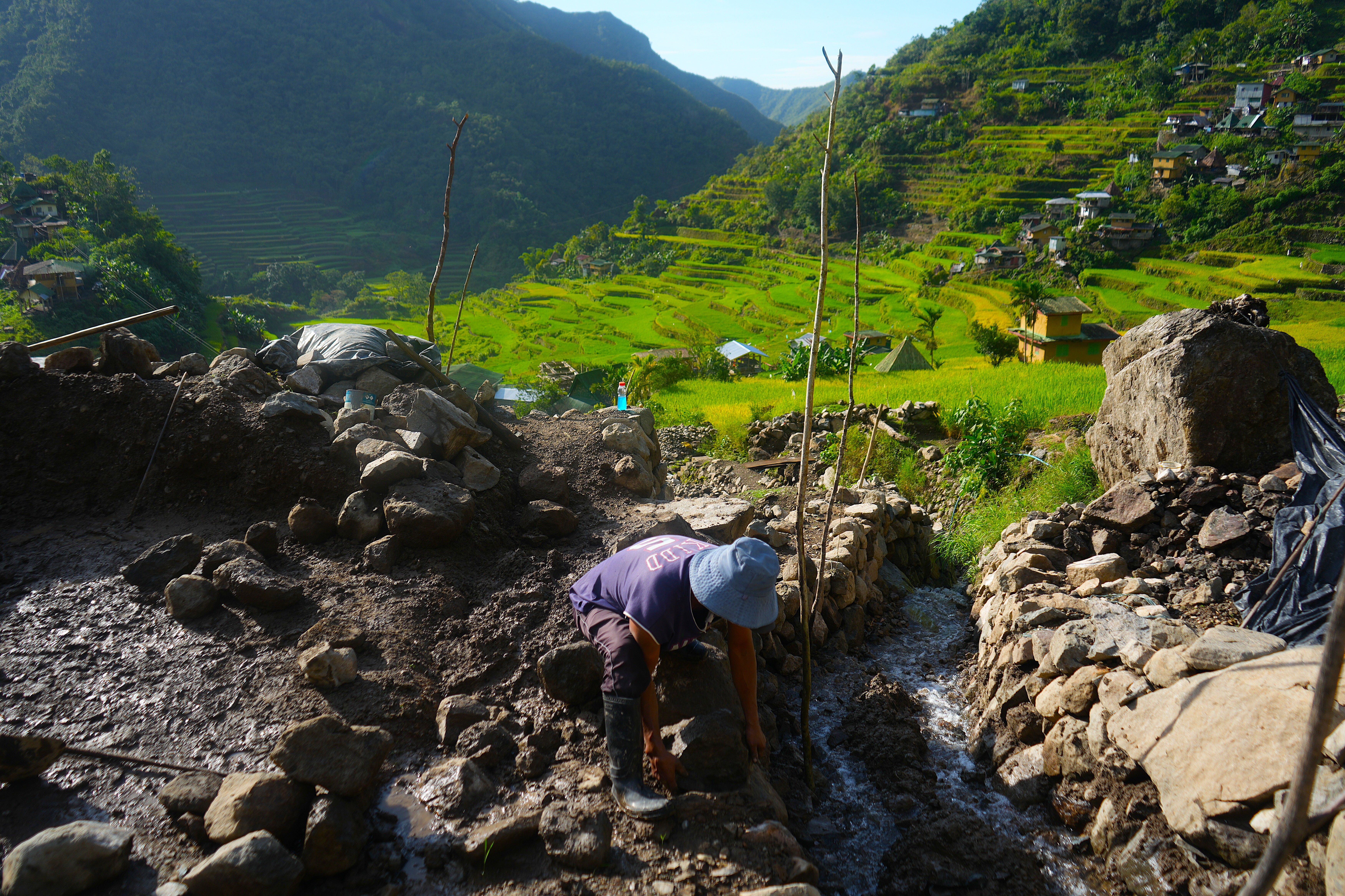 Batad resident Joel Langihon, 52, arranges piles of rocks and mud to fortify a damaged portion of his family’s rice paddy that was washed out as a result of Super Typhoon Fung-Wong last November