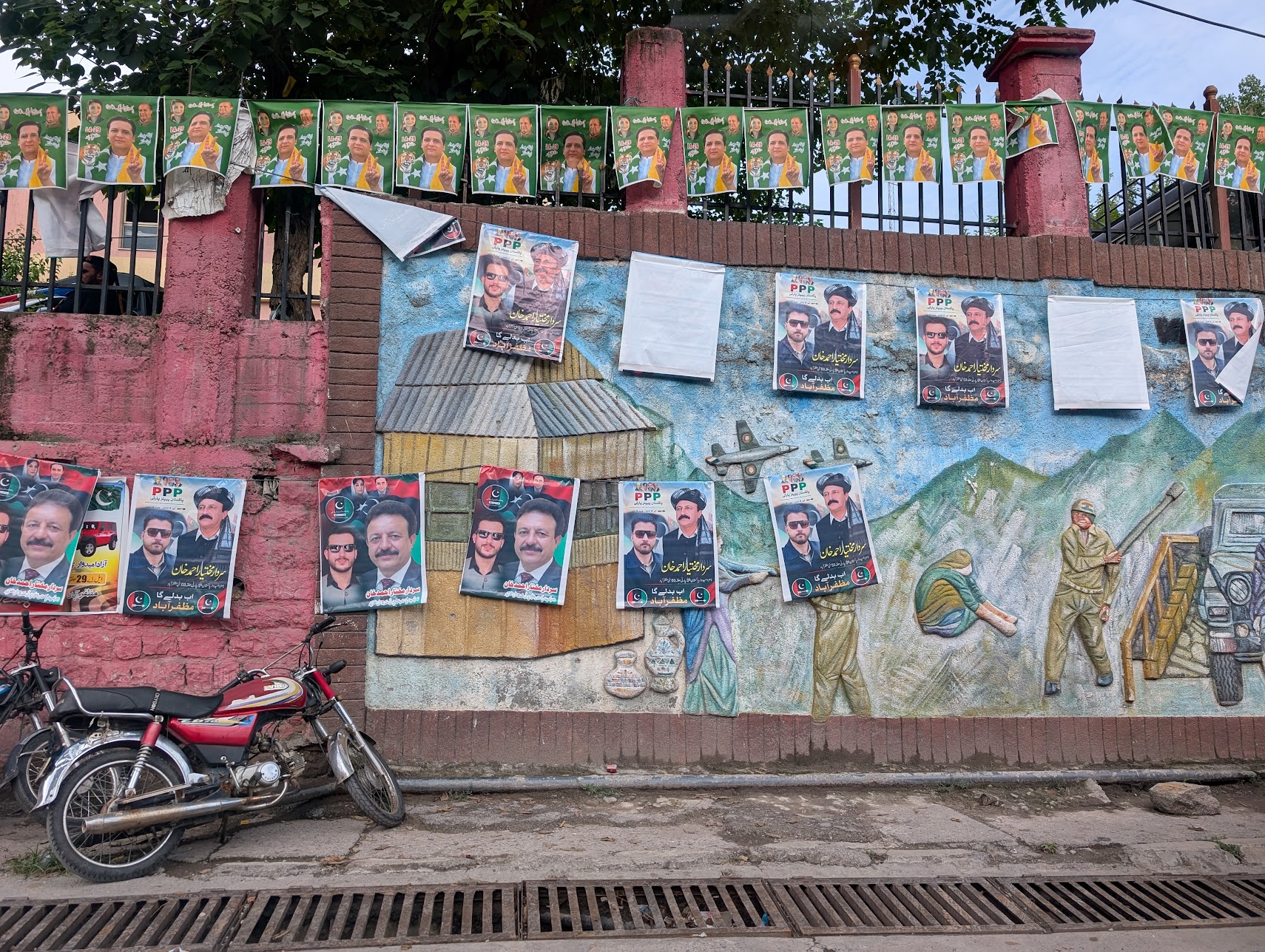 Election campaign posters plastered outside the government office compound in Muzaffarabad