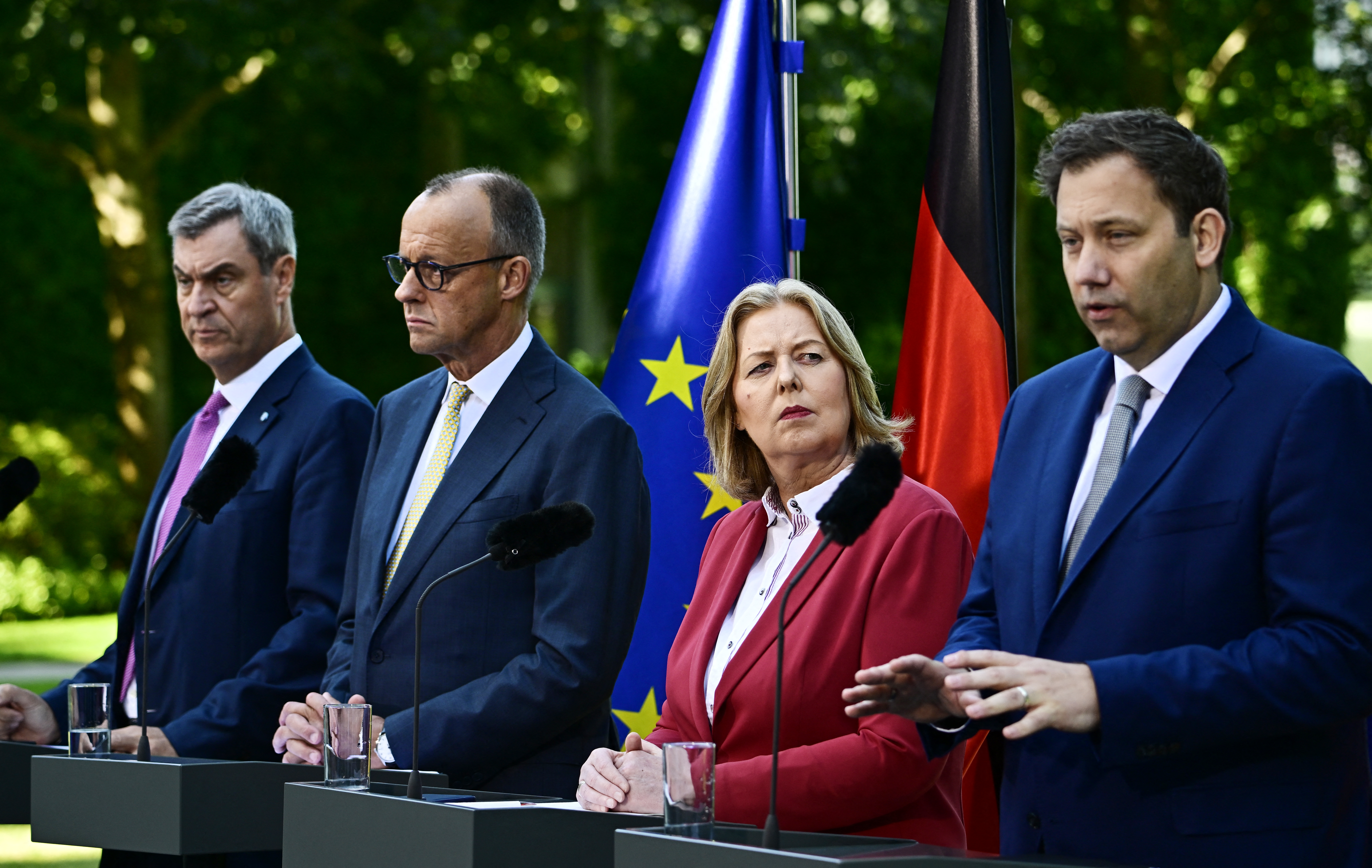 (L-R) Bavaria's State Premier and leader of the conservative Christian Social Union (CSU) Markus Soeder, German Chancellor Friedrich Merz (CDU), German Minister for Labour and Social Affairs Baerbel Bas (SPD) and German Finance Minister and Vice Chancellor Lars Klingbeil (SPD) address a press conference, on July 2, 2026 in the garden of the Chancellery in Berlin, one day after their coalition committee consultations on a major package of reforms.