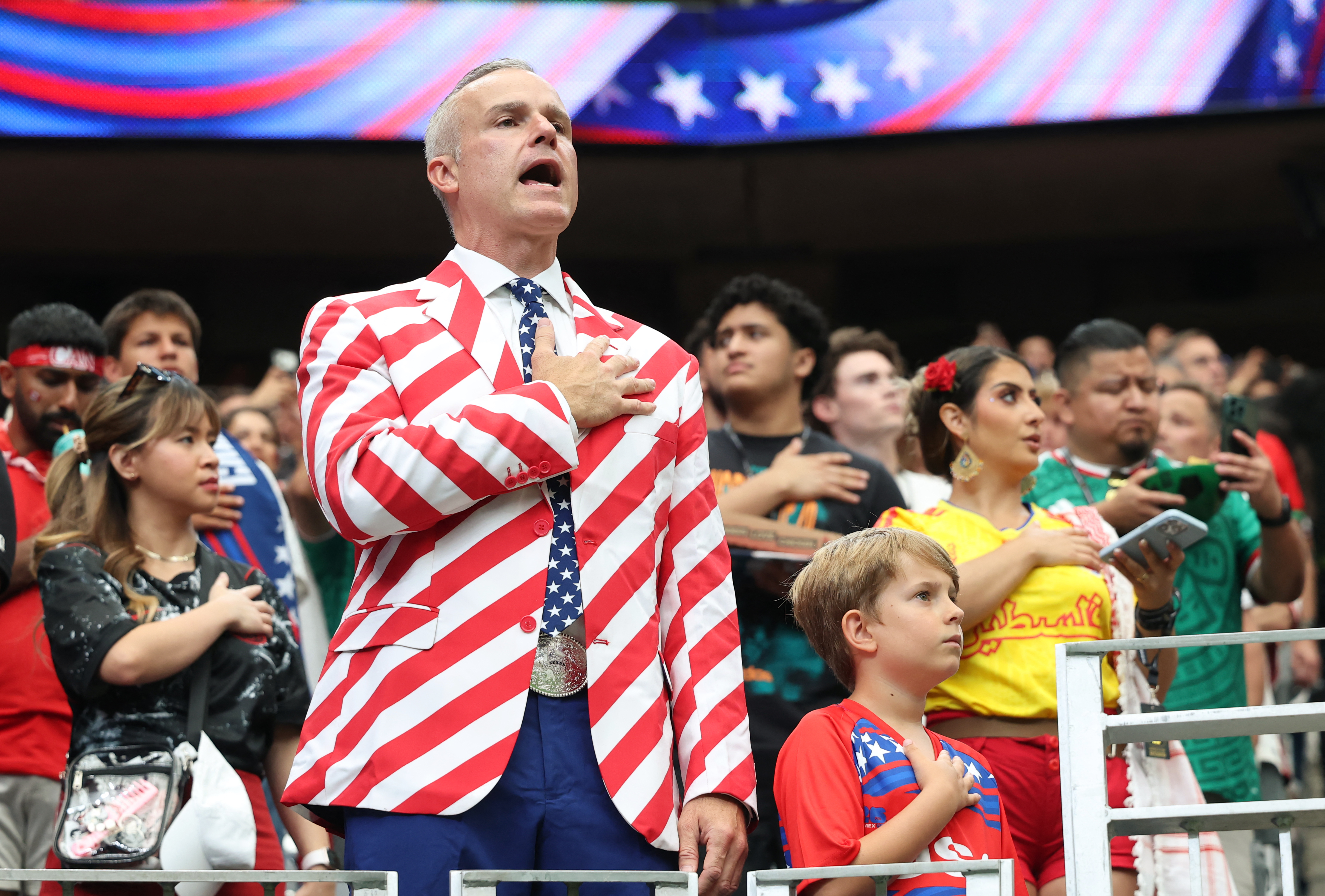 A man wears a stylish suit with the US flag as part of the Independence Day celebration ahead of the 2026 World Cup round of 16 football match between Canada and Morocco at the Houston Stadium in Houston on July 4, 2026.