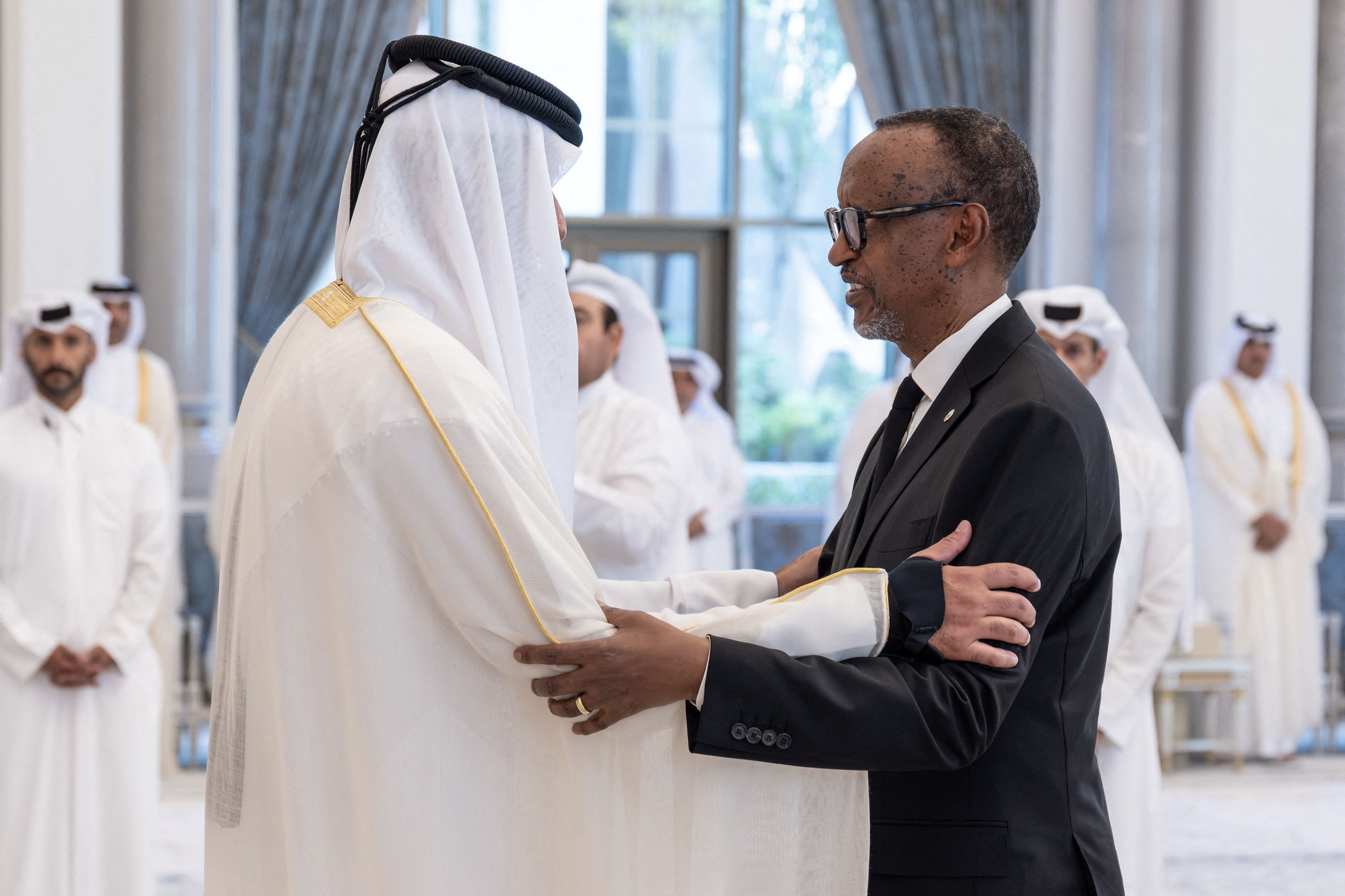 This handout photograph released by Qatar's Amiri Diwan shows Qatar's Emir Sheikh Tamim bin Hamad Al Thani (L) receiving condolences from Rwanda's President Paul Kagame following the death of his father, former leader Sheikh Hamad bin Khalifa Al Thani, at Lusail Palace on the outskirts of Doha on July 13, 2026.
