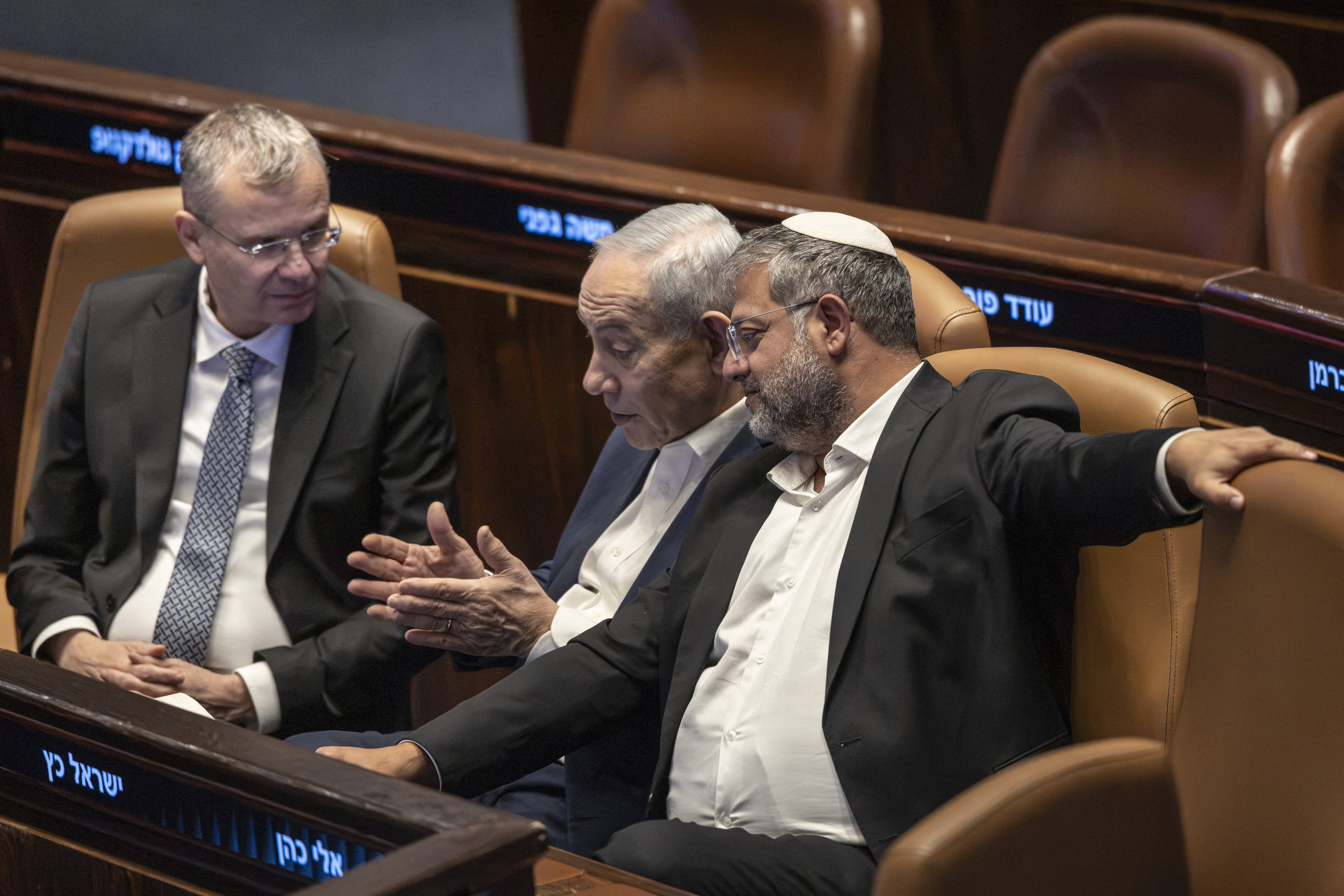 Israel's Prime minister Benjamin Netanyahu (C), Israel's far-right National Security Minister Itamar Ben-Gvir (R) and Deputy Prime Minister of Israel Yariv Levin speak together.