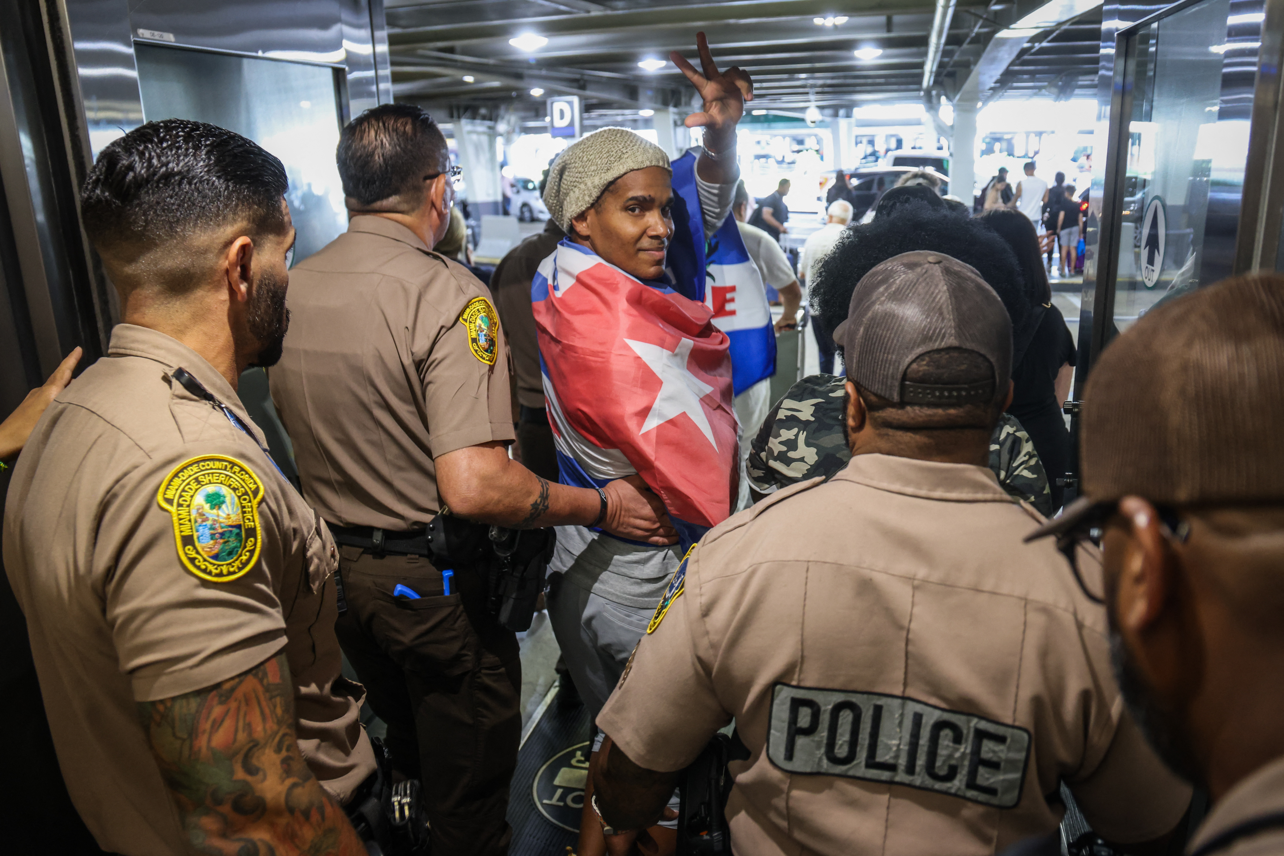 Luis Manuel Otero Alcántara, artist and opponent of the Cuban regime, greets upon his arrival at Miami International Airport on July 18, 2026.