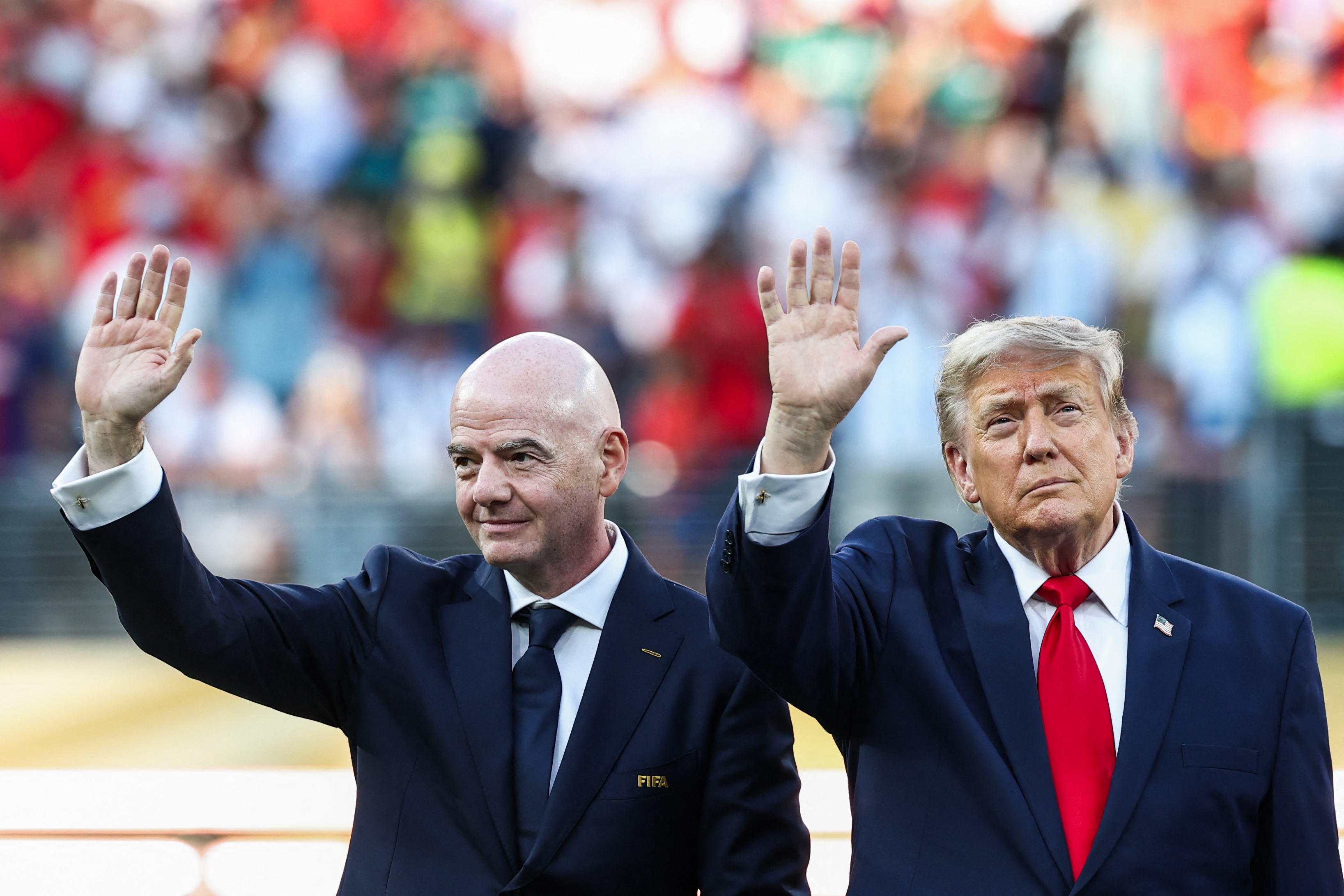US President Donald Trump (R) and FIFA President Gianni Infantino (L) wave during the award ceremony of the 2026 World Cup football tournament final match between Spain and Argentina at the New York/New Jersey Stadium in East Rutherford on July 19, 2026.