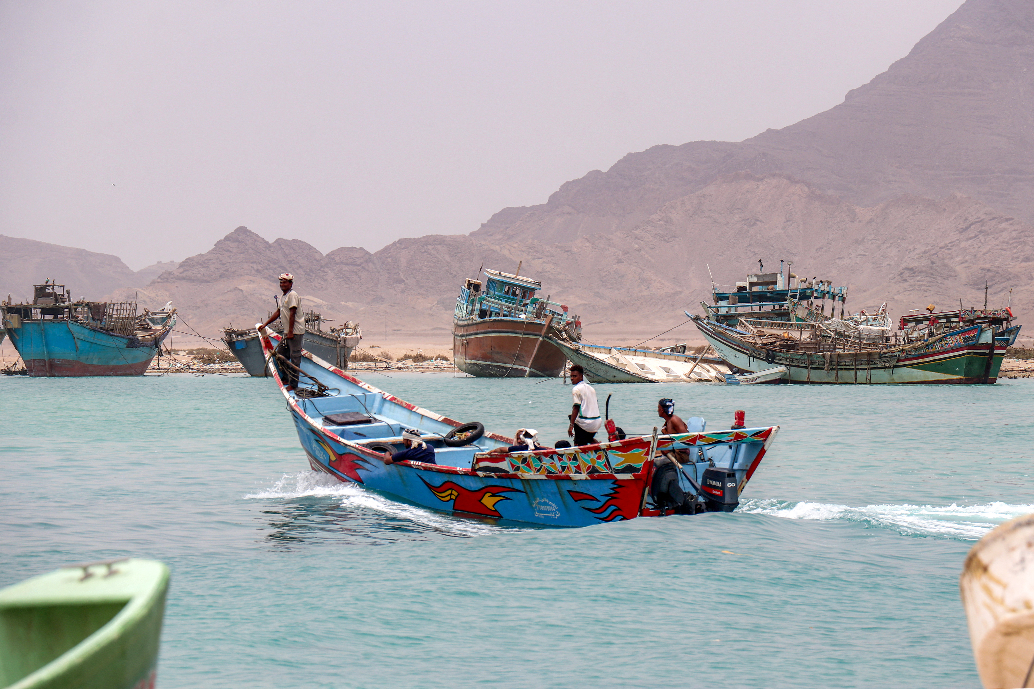 People sit in a fishing boat sailing the Bab el-Mandeb Strait off of Yemen's southern Taiz province on July 25, 2026.