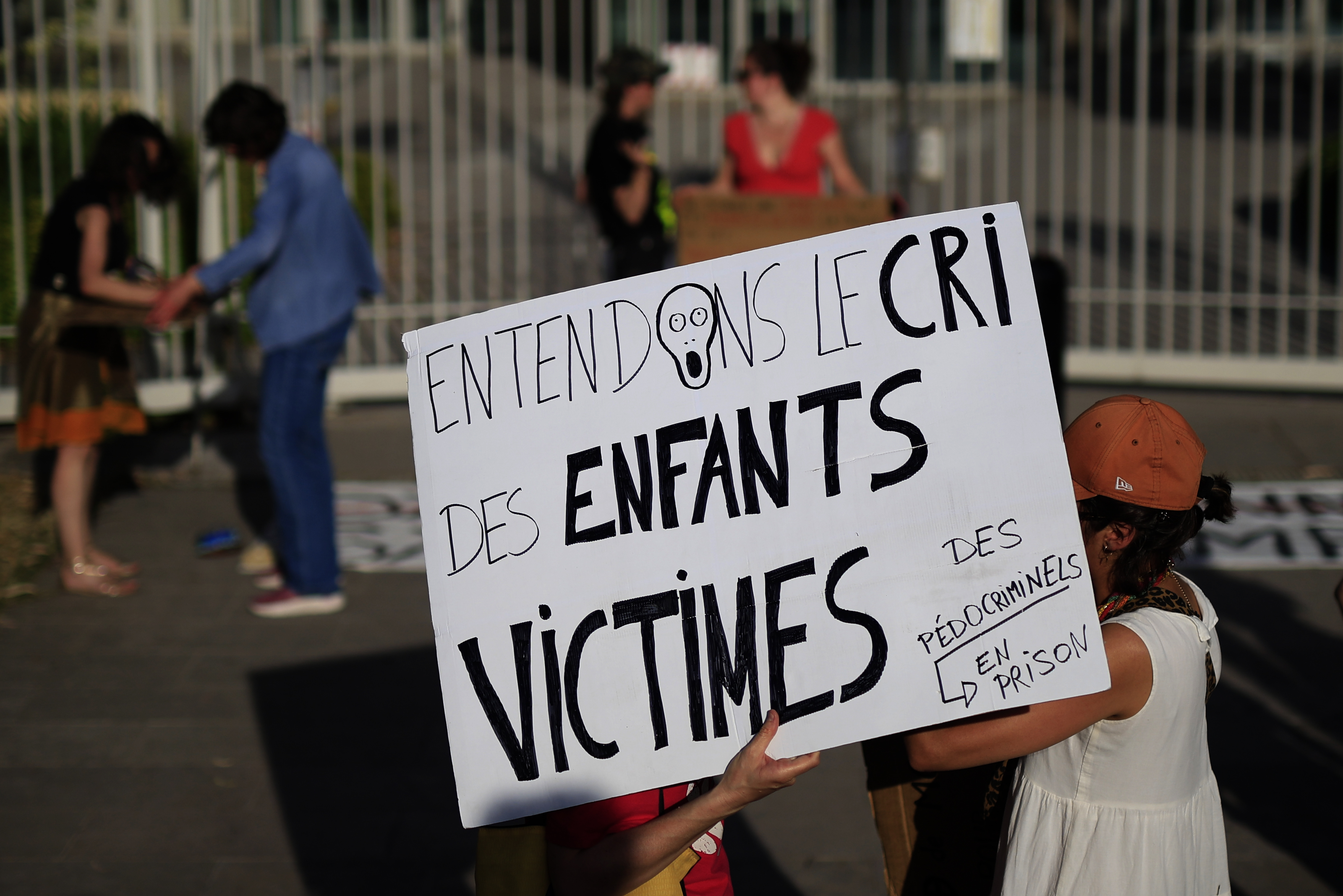 epa13039740 A protester carries a placard reading, “let us hear the cry of the child victims,” during a demonstration outside the courthouse in Montpellier, southern France, 15 June 2026. Feminist and child advocacy organisations called for protests following the killing of Lyhanna, amid criticism of the handling of the case. EPA/Guillaume Horcajuelo