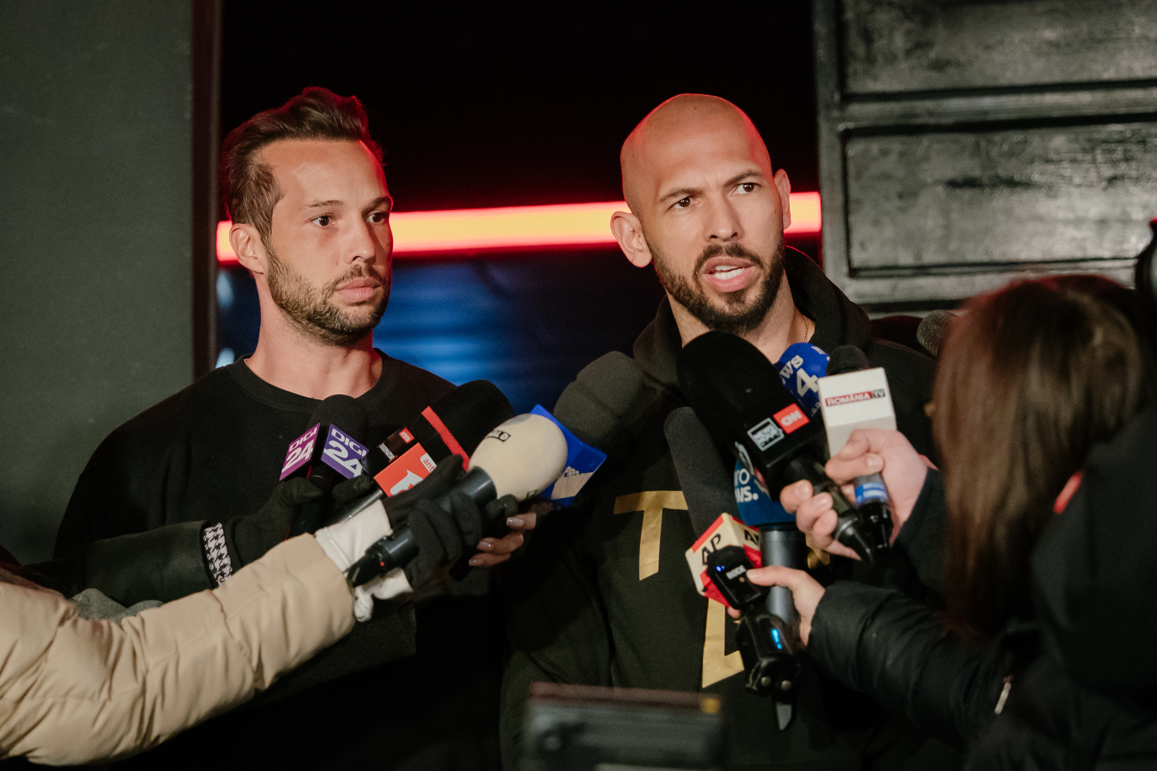 Andrew Tate and his brother Tristan Tate talk to the media outside their residence on March 23, 2025 in Bucharest, Romania. [Andrei Pungovschi/Getty Images]
