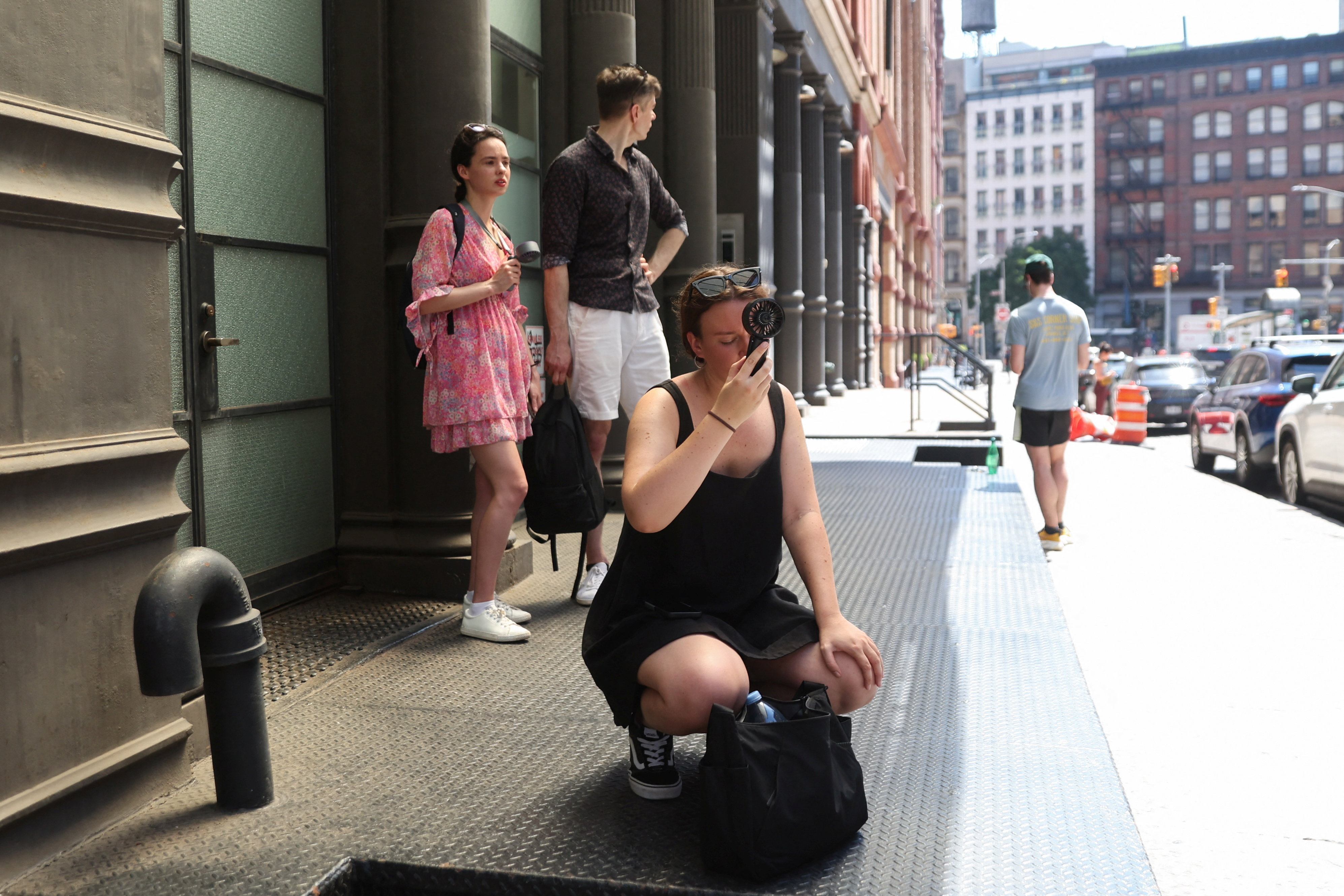 Women use fans to cool off themselves outside singer Taylor Swift's residence in Manhattan amid reported wedding celebrations for her and National Football League (NFL) player Travis Kelce, during a heatwave in New York, U.S., July 3, 2026. REUTERS/Heather Khalifa