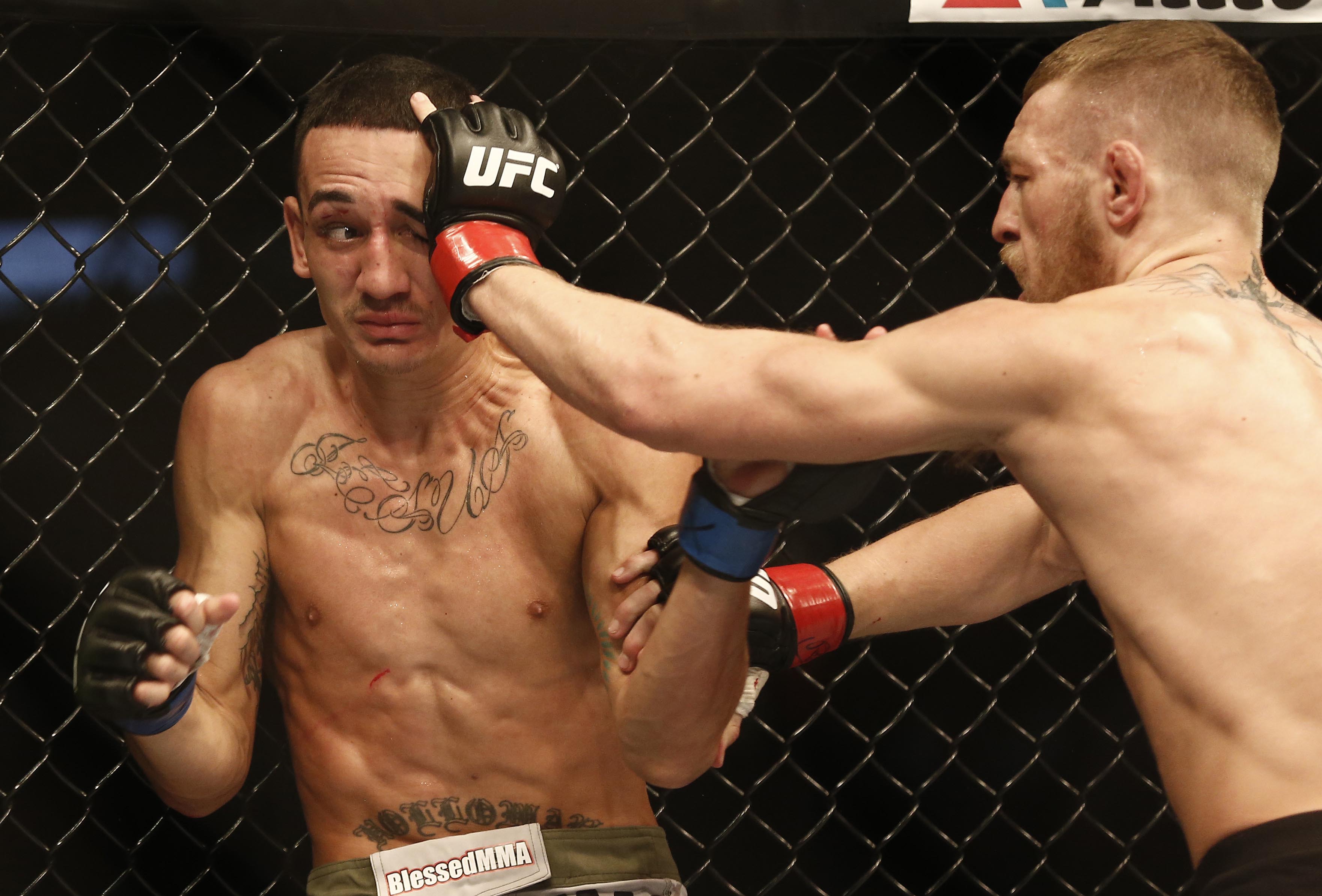 Aug 17, 2013; Boston, MA, USA; Conor McGregor (black shorts) and Max Holloway (white shorts) fight during a UFC featherweight match at the TD Garden. McGregor won after three rounds by judges decision. Mandatory Credit: Winslow Townson-USA TODAY Sports