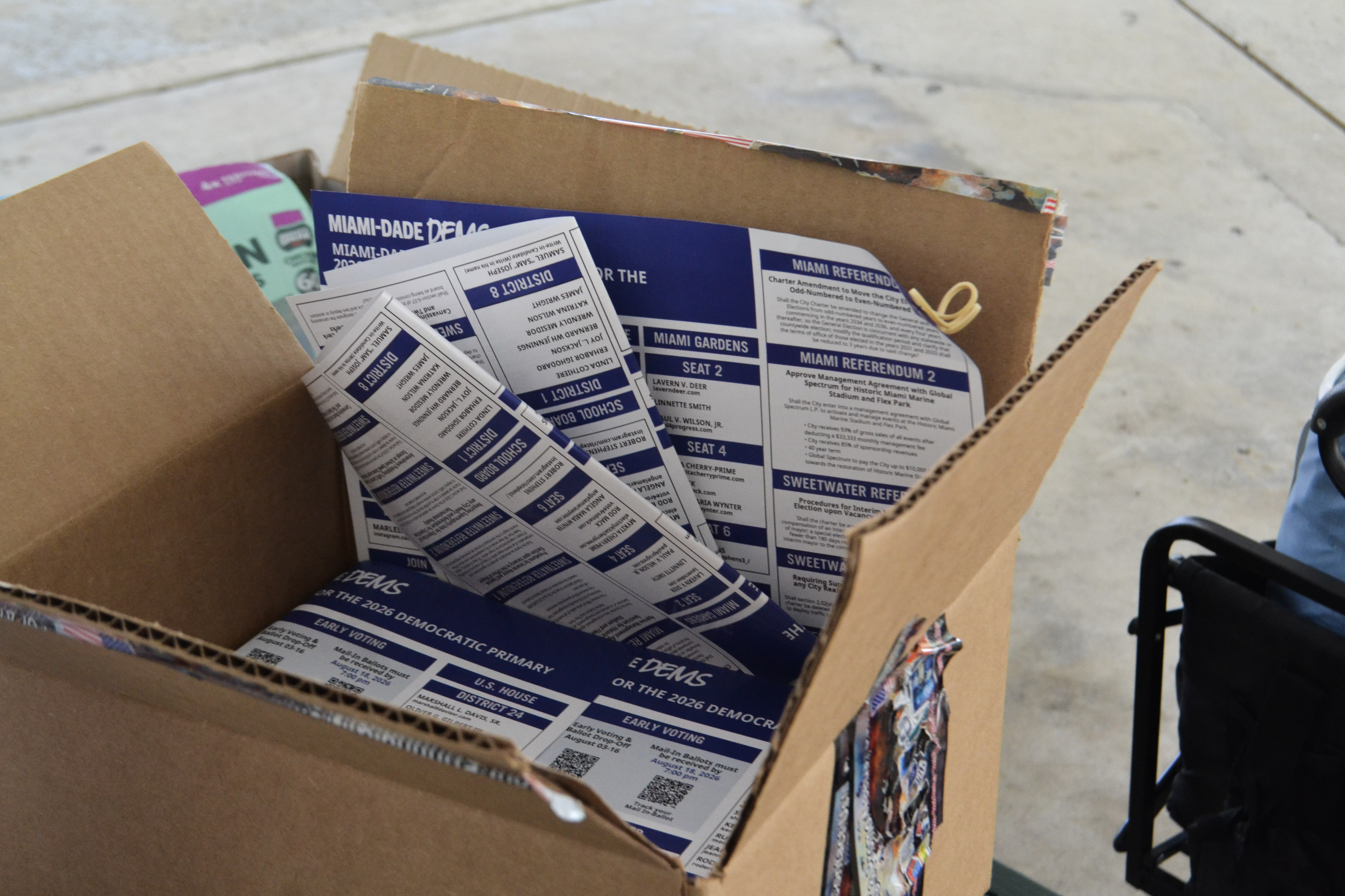 A box of voter guides rests on a picnic table at a Miami-Dade Democratic Party canvassing event in Miami.