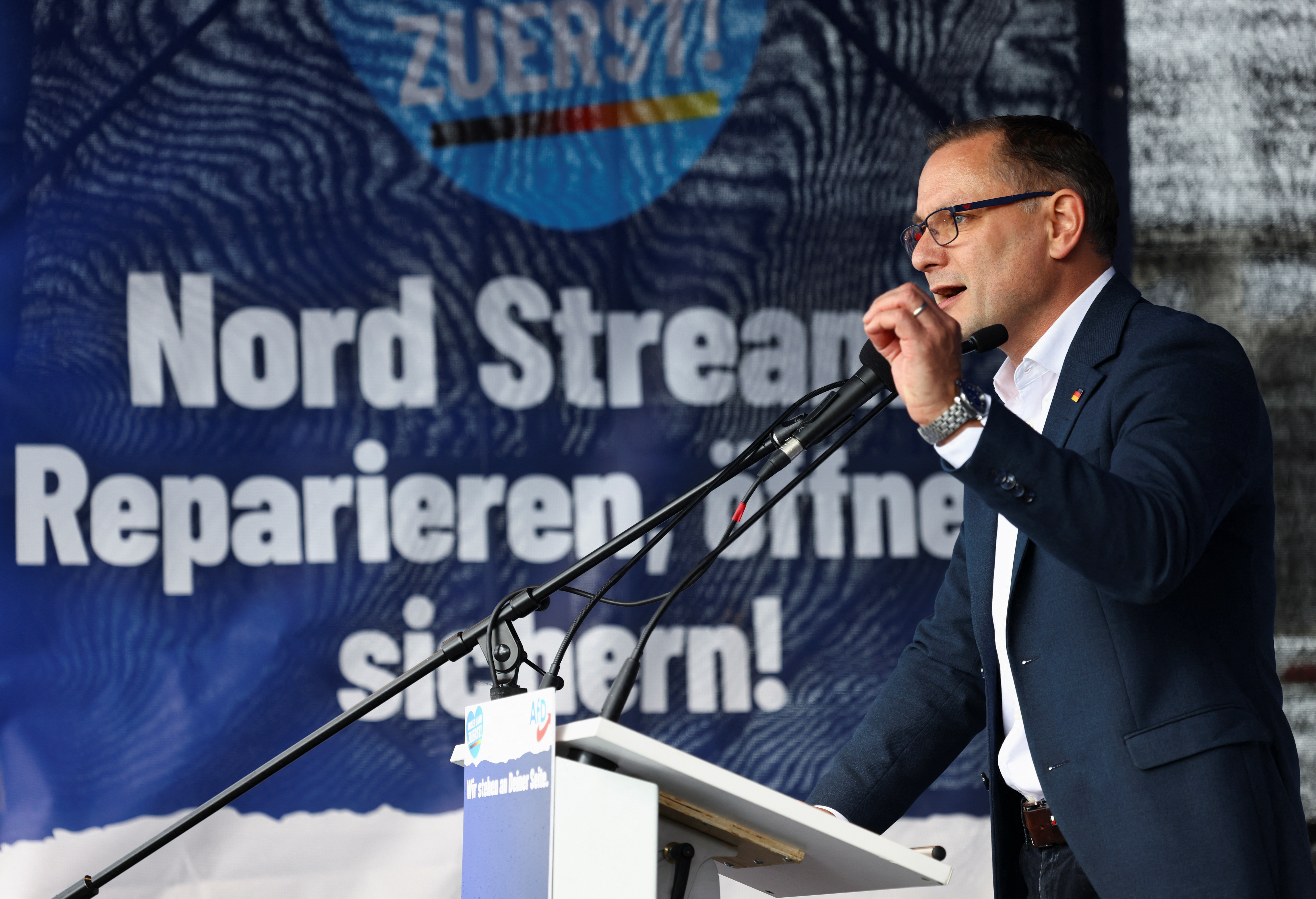 Leader of Alternative for Germany (AfD) Tino Chrupalla speaks next to a banner that reads "Nord Stream: repair, open, secure" during a protest against the government, amid skyrocketing energy prices, in Berlin, Germany, October 8, 2022. REUTERS/Christian Mang
