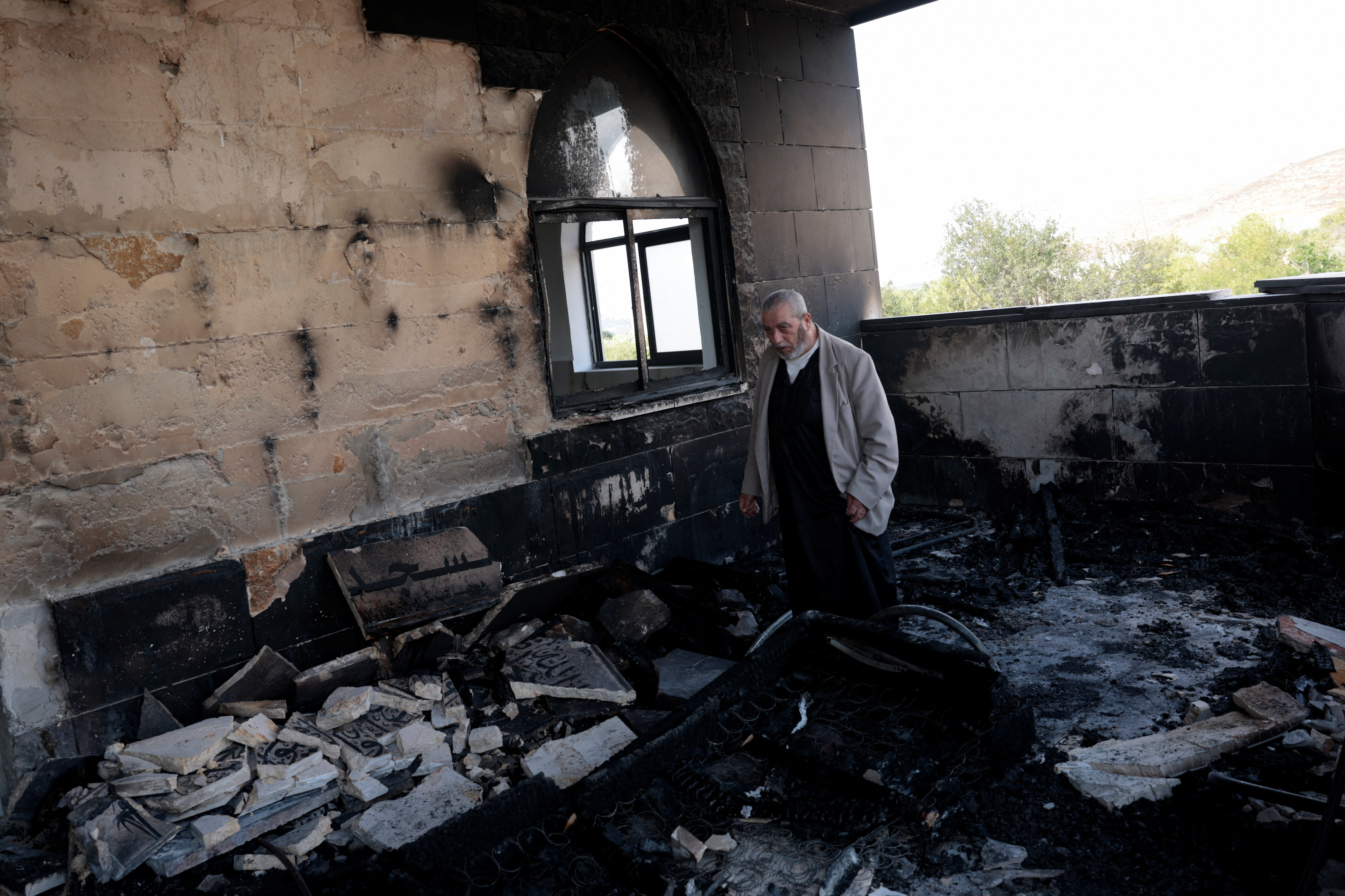 A Palestinian man inspects the damage at a mosque that Palestinians say was damaged by Israeli settlers in Qusra near Nablus in the Israeli-occupied West Bank on July 26, 2026