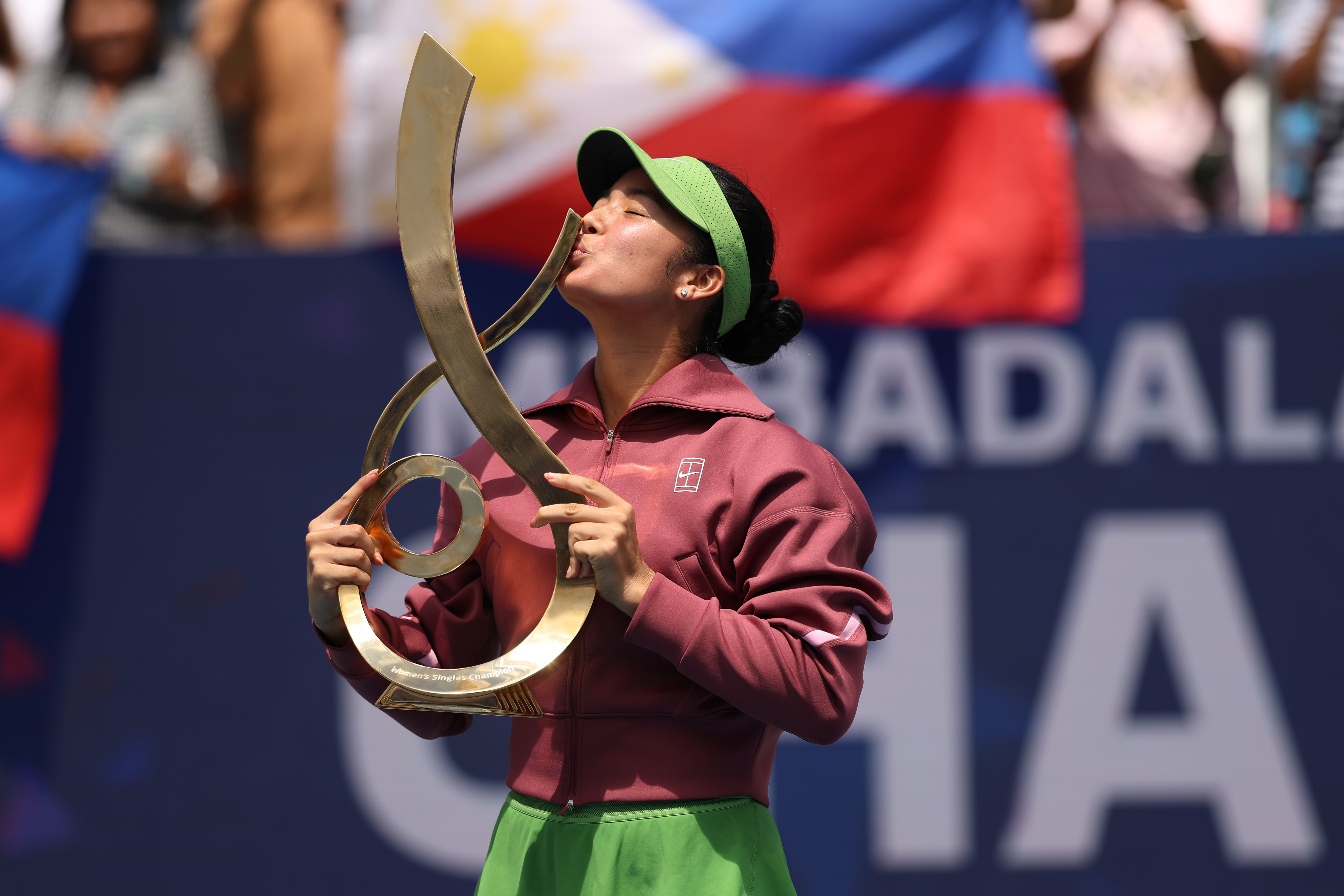 Alexandra Eala (PHI) kisses the championship trophy during the trophy ceremony after her match against Jessica Pegula (USA) (not pictured) in the women's singles final of the 2026 Mubadala DC Open