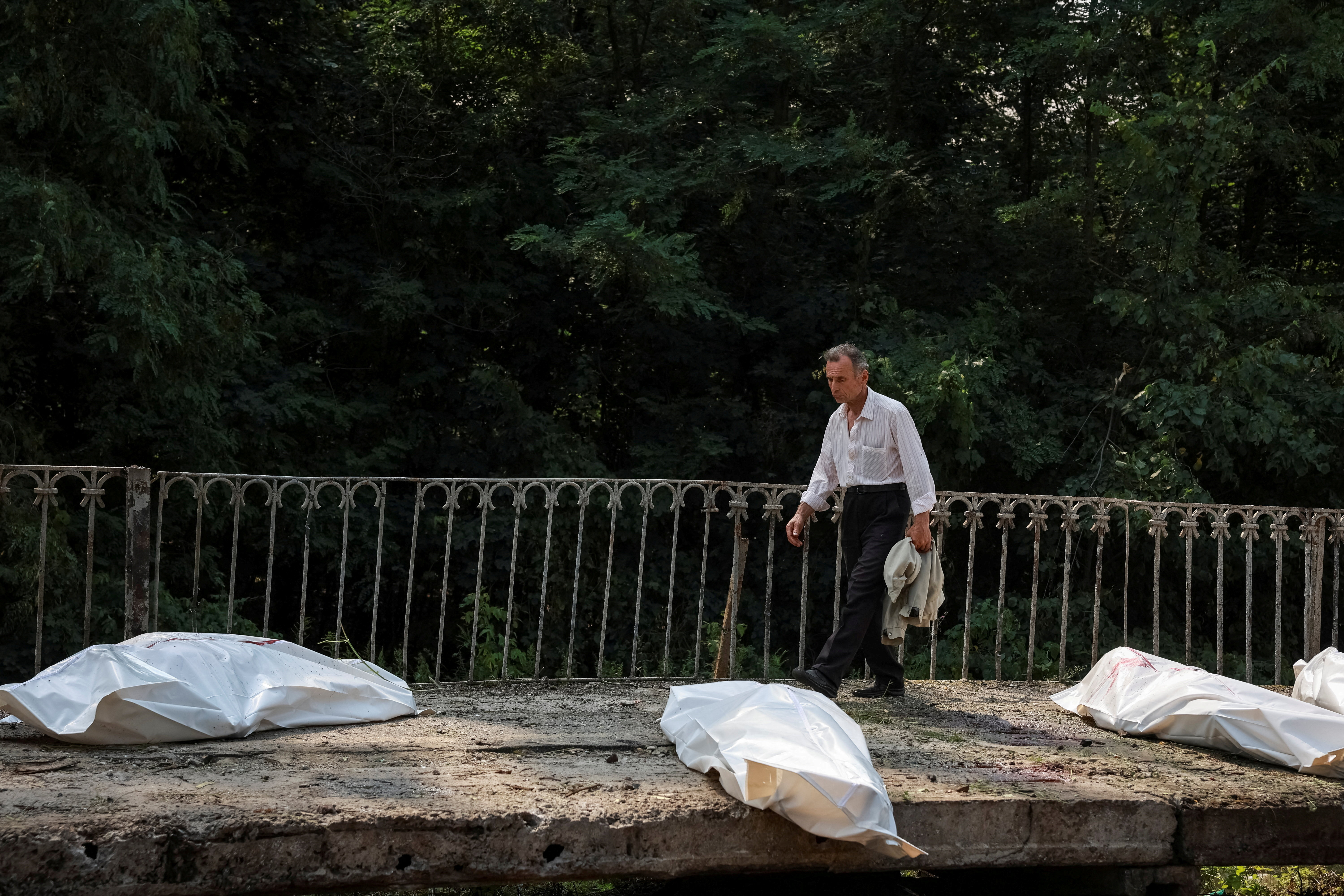 A man walks near bodies of killed residents in body bags at a railway station, the site of Russian air strike, amid Russia's attack on Ukraine, in Kyiv region, Ukraine August 5, 2026. REUTERS/Stringer TPX IMAGES OF THE DAY